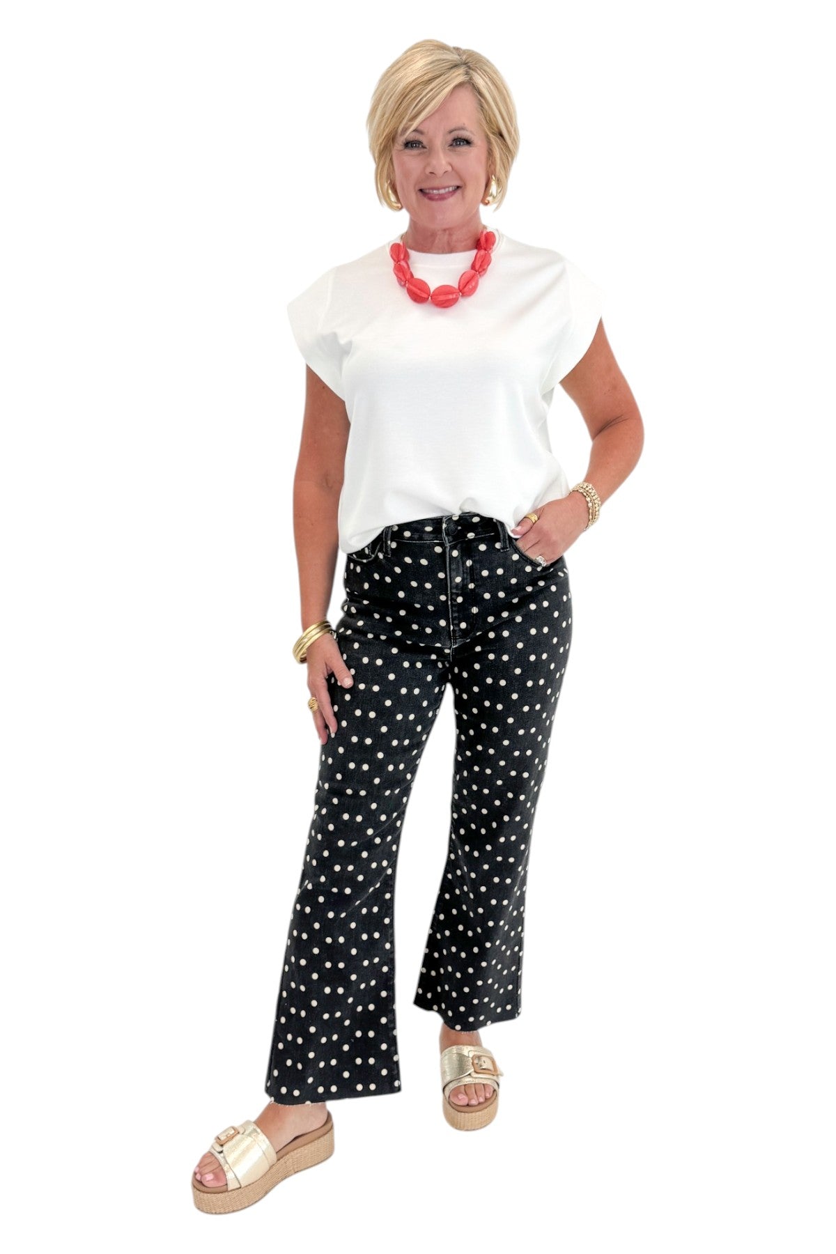 Front view of woman wearing Swagger Boutiqueās Black & White Polka Dot Crop Flare Jeans by Just Black Denim with top against white studio background.