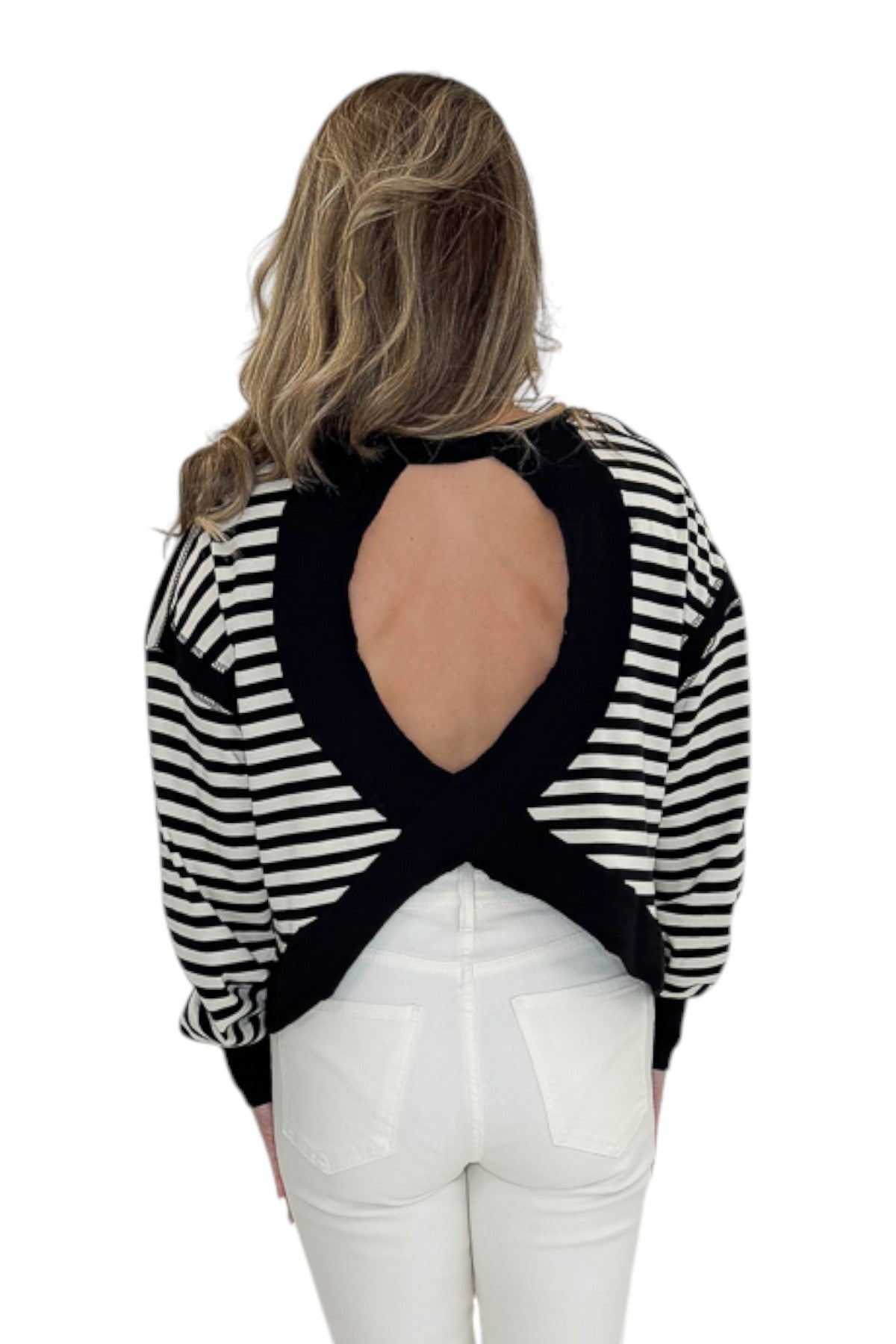 Back view of woman wearing Swagger Boutiqueās Black & White Striped Cut Out Back Sweatshirt with jeans against white studio background.