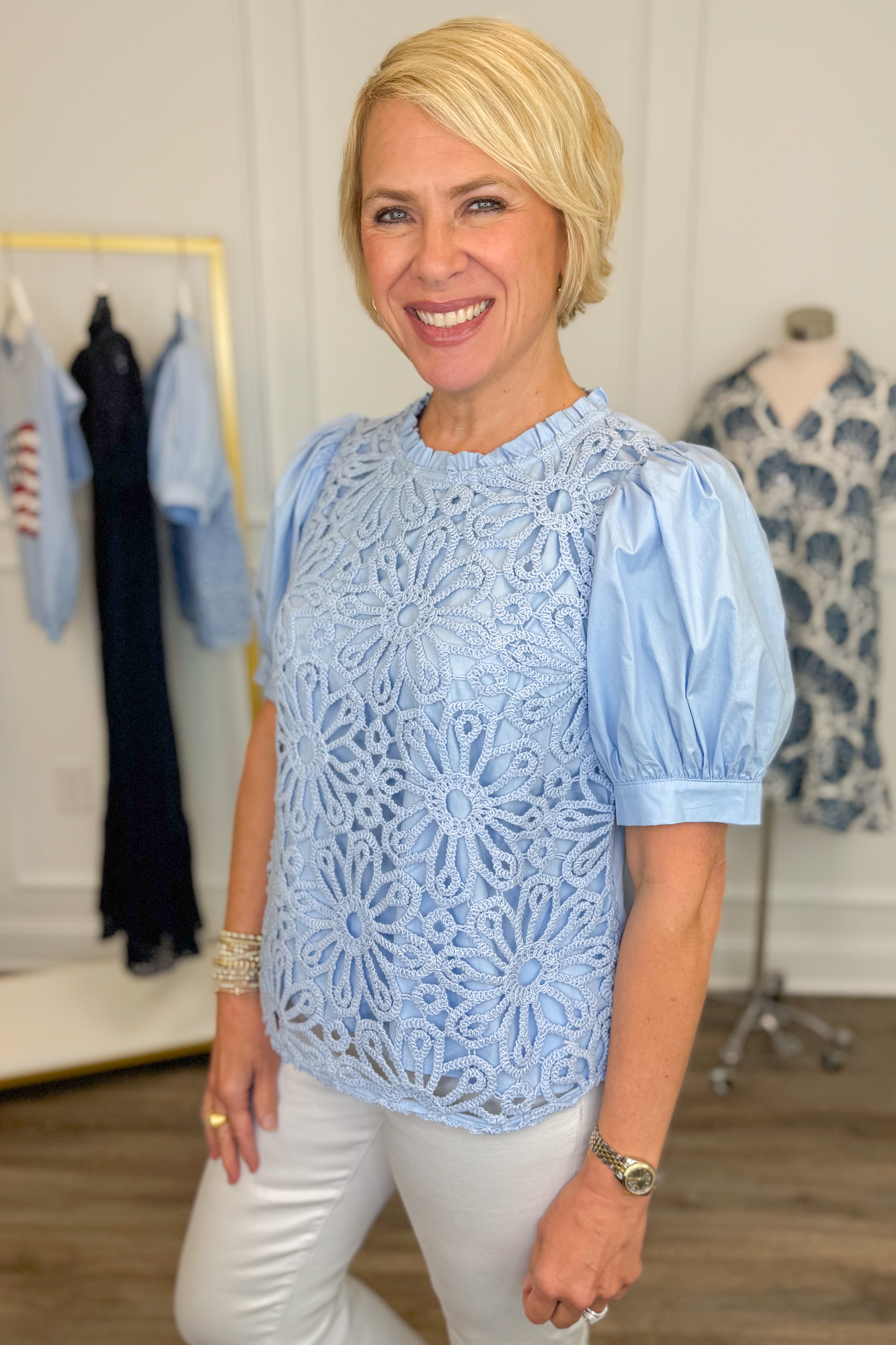 Side view of woman wearing Swagger Boutique’s Blue Crochet Puff Sleeve Top with jeans against white studio background.