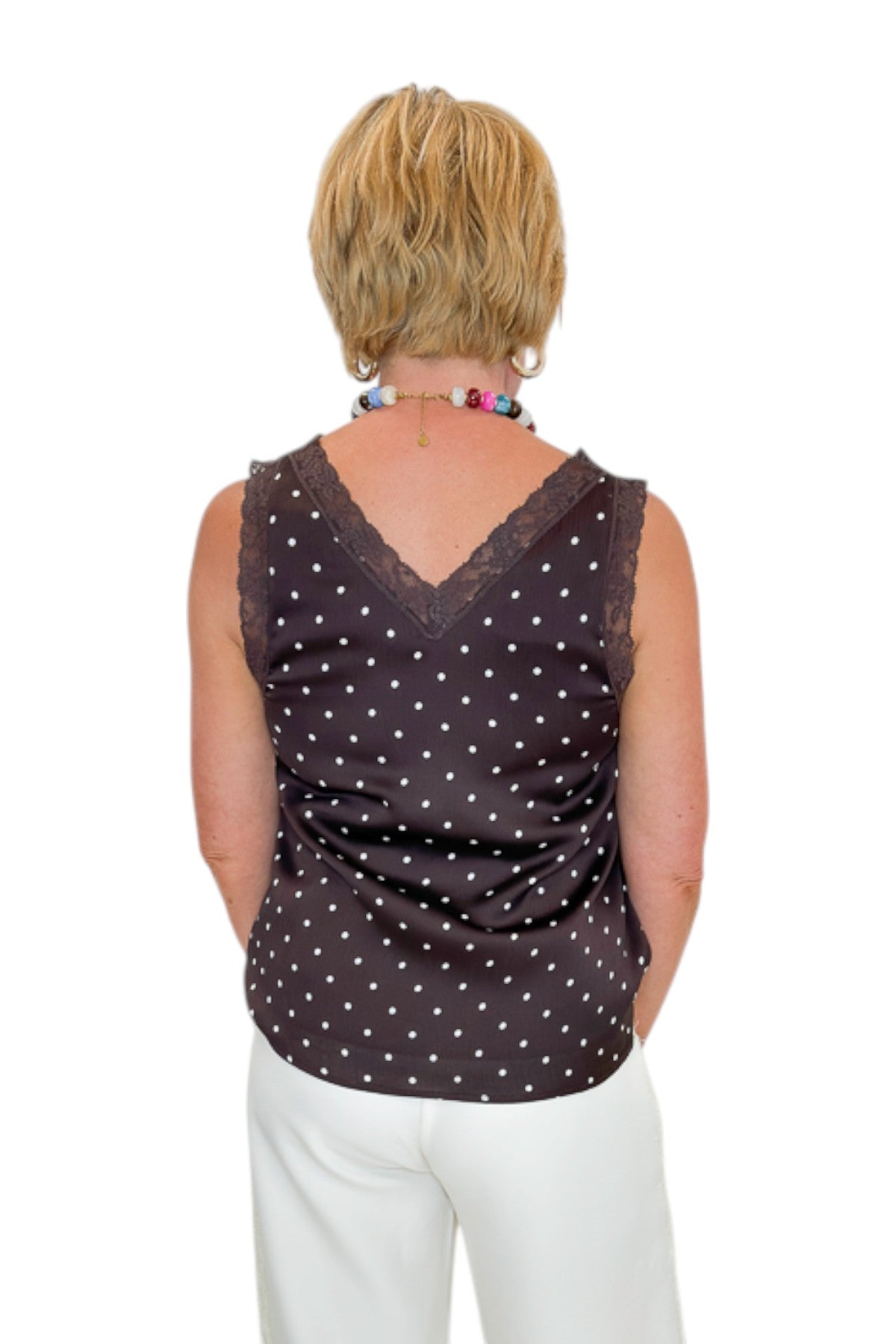 Back view of woman wearing Swagger Boutique’s Brown Polka Dot Lace Trim Tank with Cream Lace Lined Pants against white studio background.