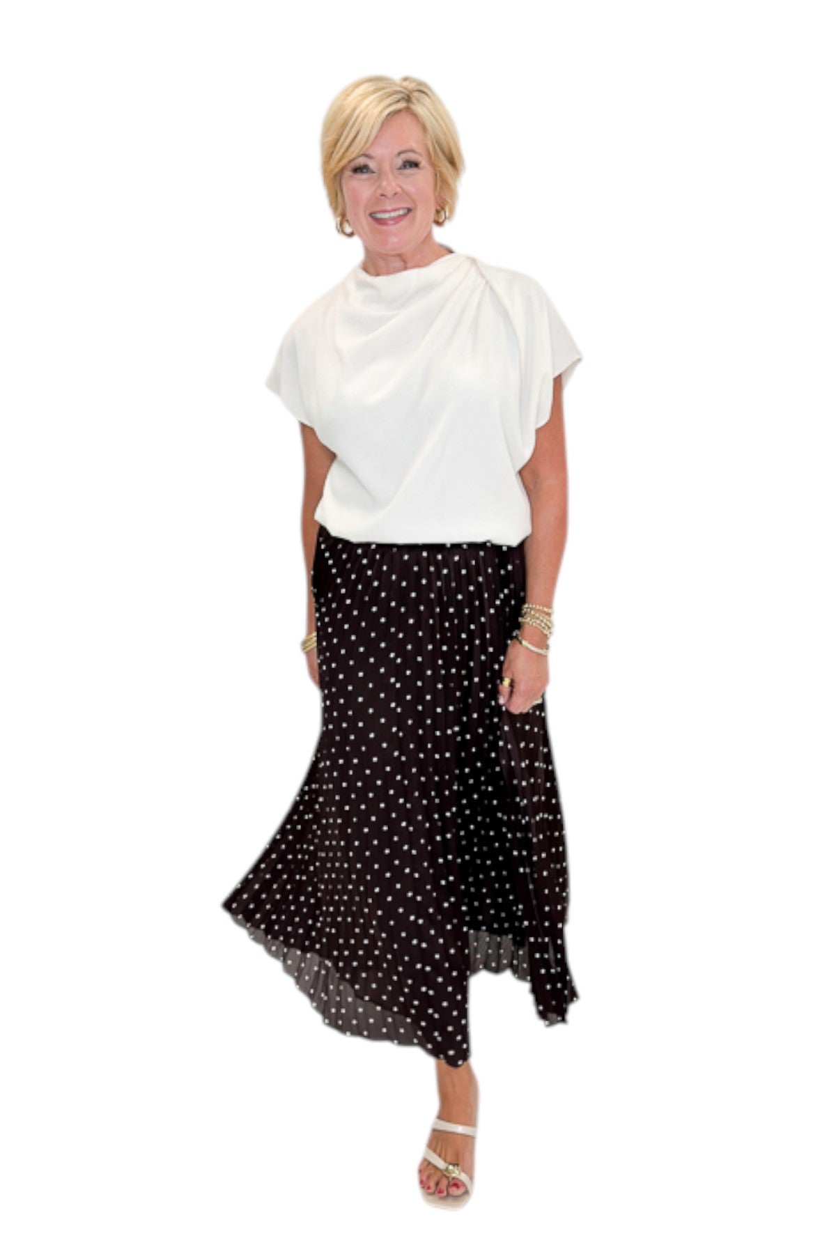 Front view of woman wearing Swagger Boutique’s Brown Polka Dot Pleated Skirt with top against white studio background.