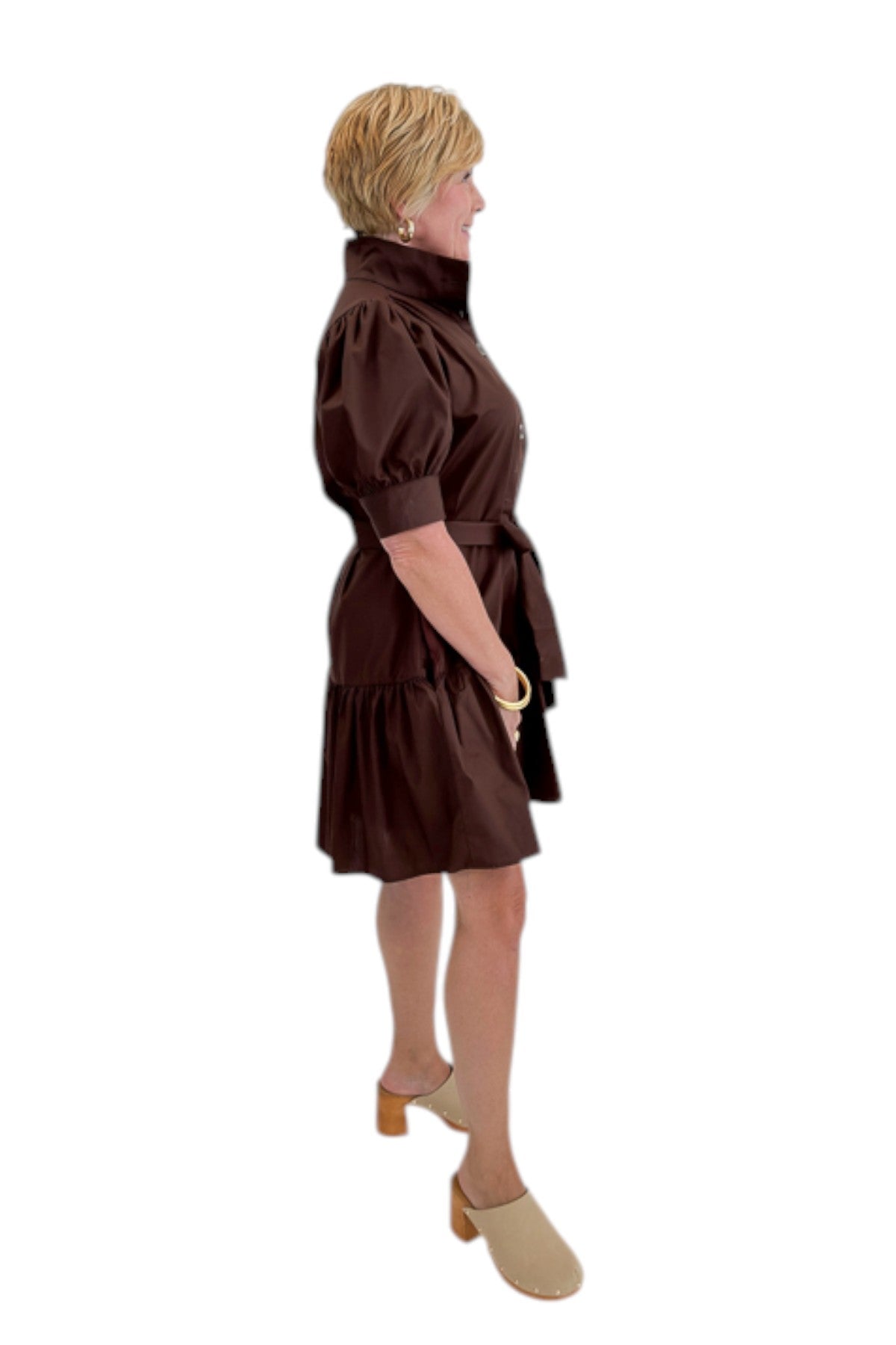 Side view of woman wearing Swagger Boutique’s Brown Ruffle Mini Dress by Entro against white studio background.