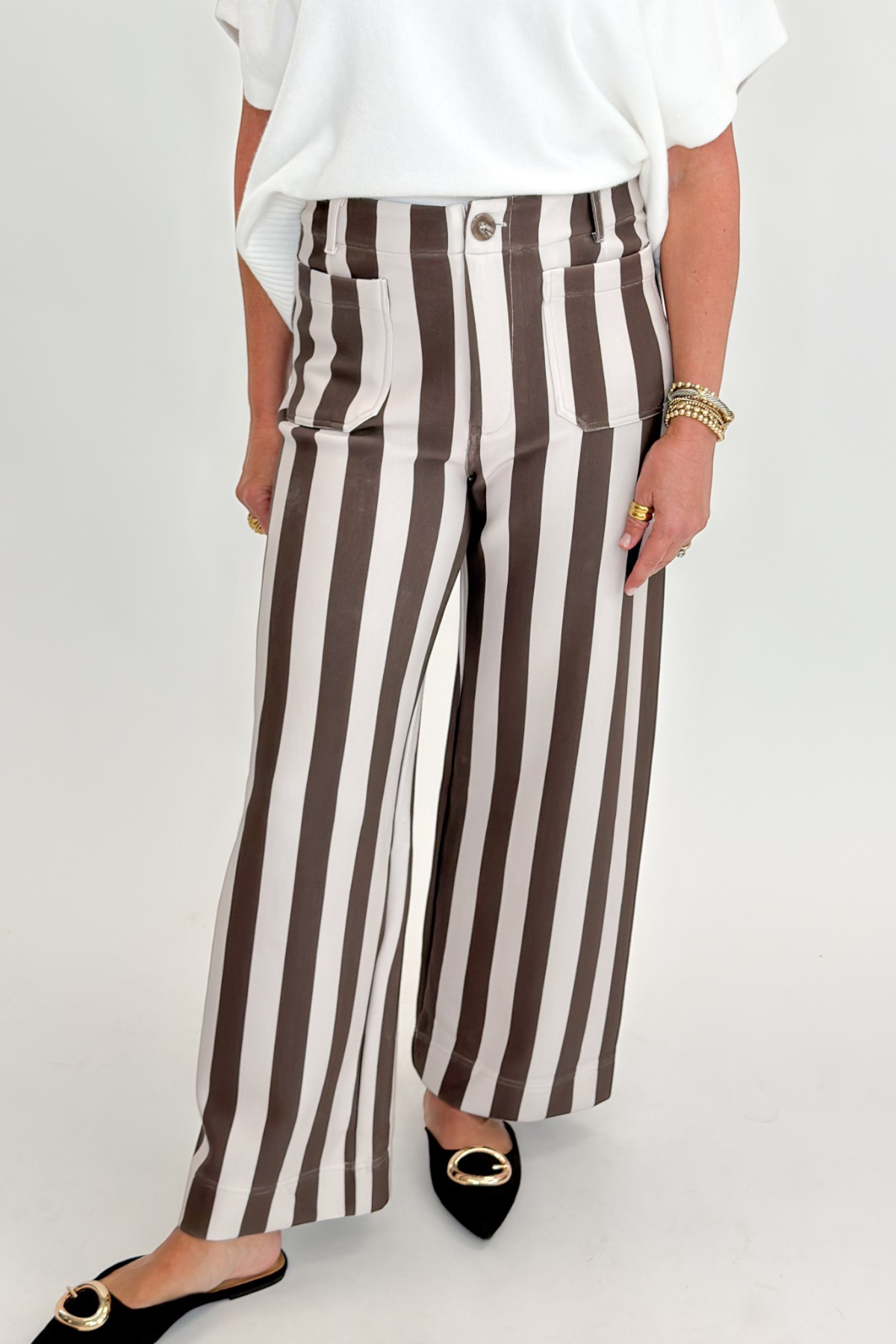 Front view of woman wearing Swagger Boutique’s sweater with Brown & Beige Striped Pants by Entro against white studio background.