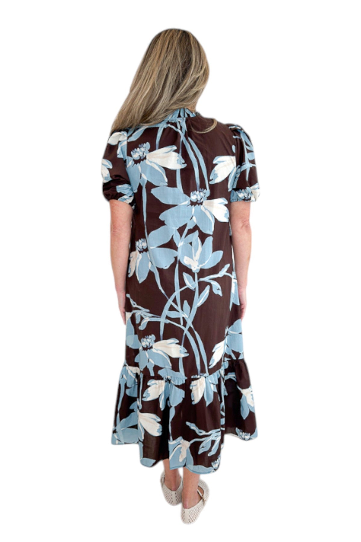 Back view of woman wearing Swagger Boutique’s Brown & Blue Floral Midi Dress by Entro against white studio background.