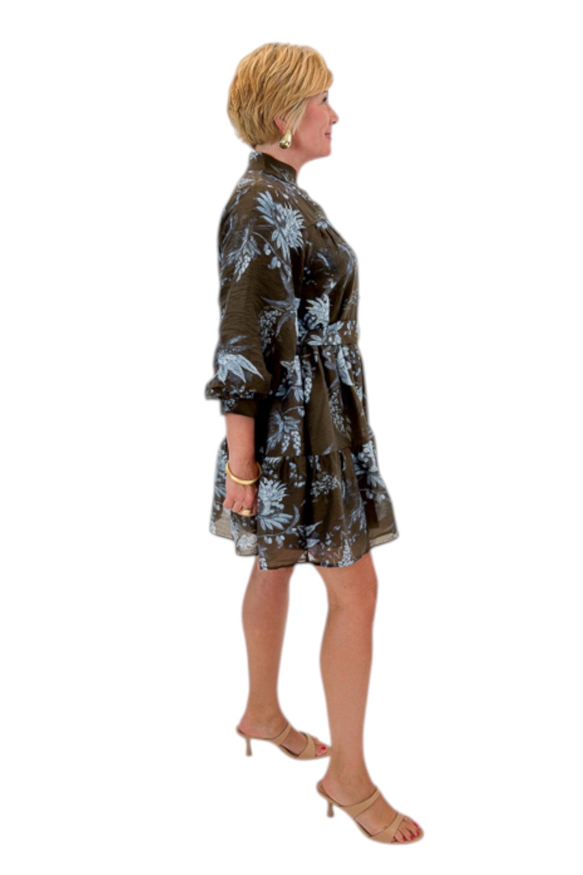Side view of woman wearing Swagger Boutiqueās Brown & Blue Floral Tie Waist Mini Dress against white studio background.