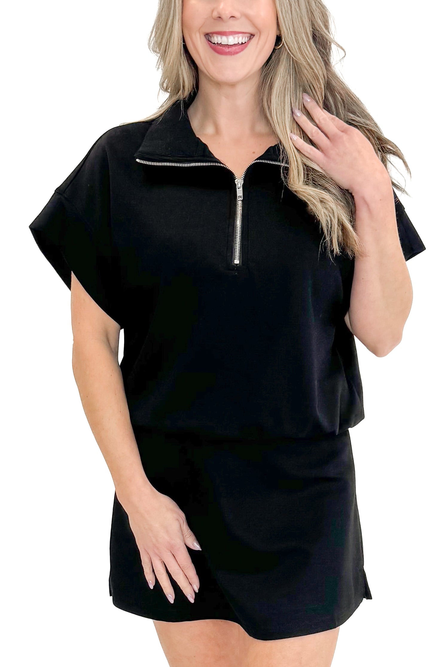Front detail view of woman wearing Black Athleisure Skirt with matching sweatshirt against white studio background.