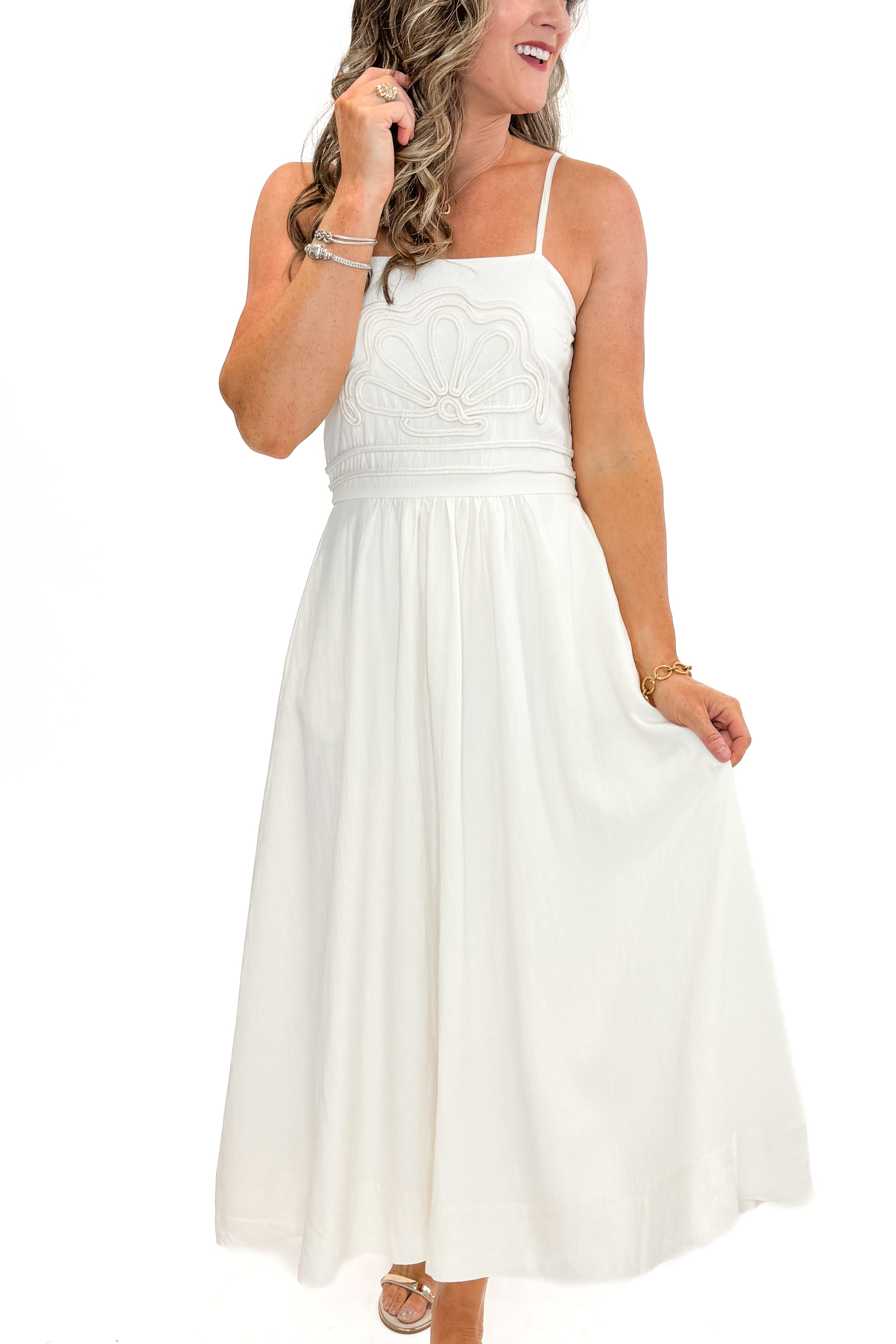 Front view of woman wearing Cream Shell Embroidered Midi Dress by TCEC with gold bar sandals against white studio background.