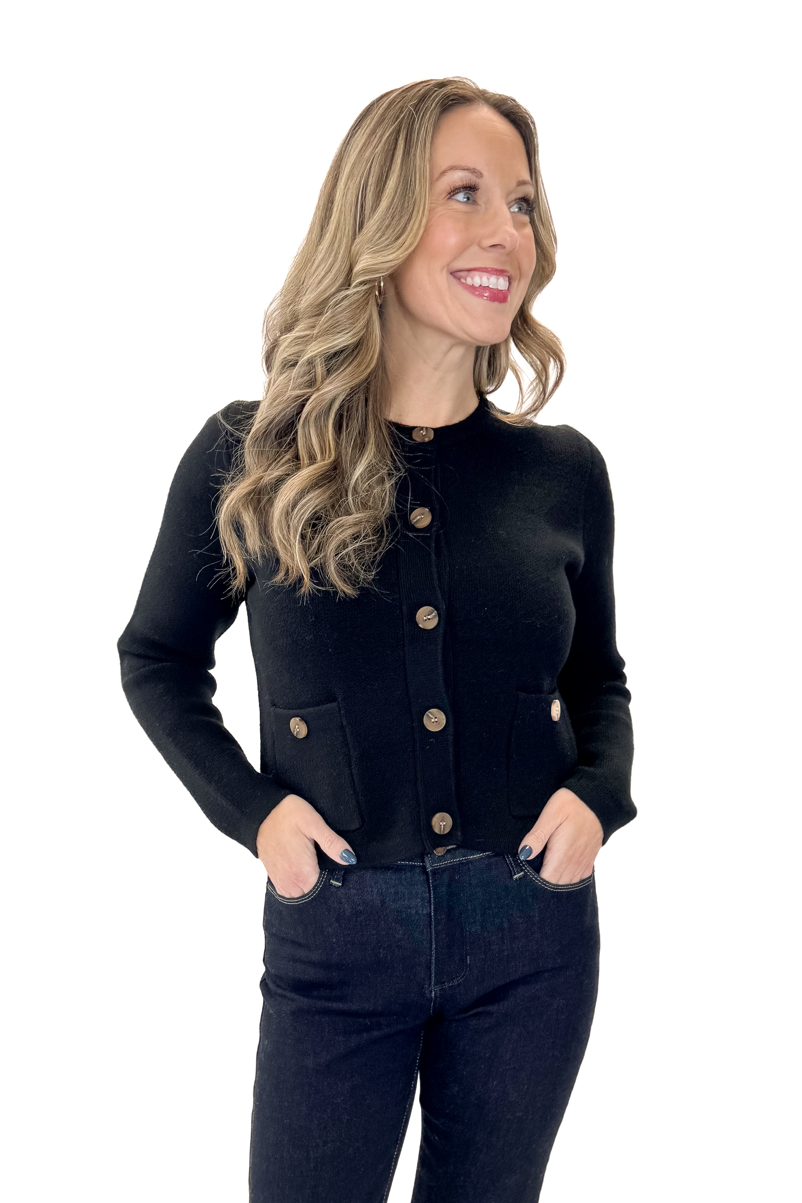 Front view of woman wearing Black Button Detail Cardigan with jeans against white studio background.