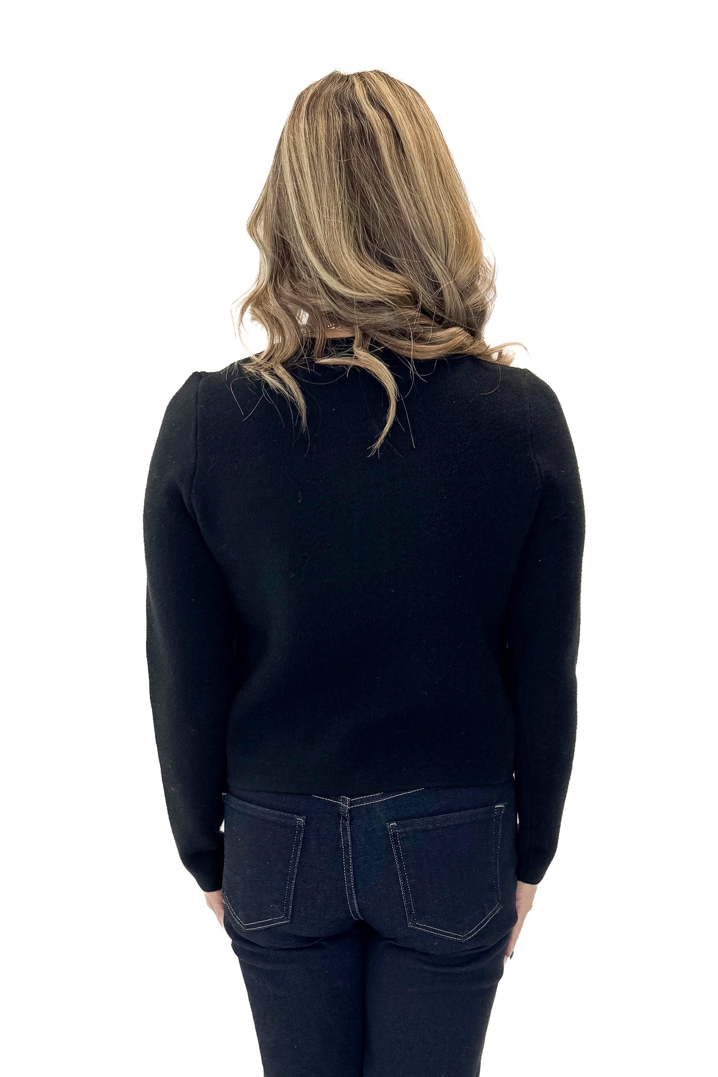 Back view of woman wearing Black Button Detail Cardigan with jeans against white studio background.