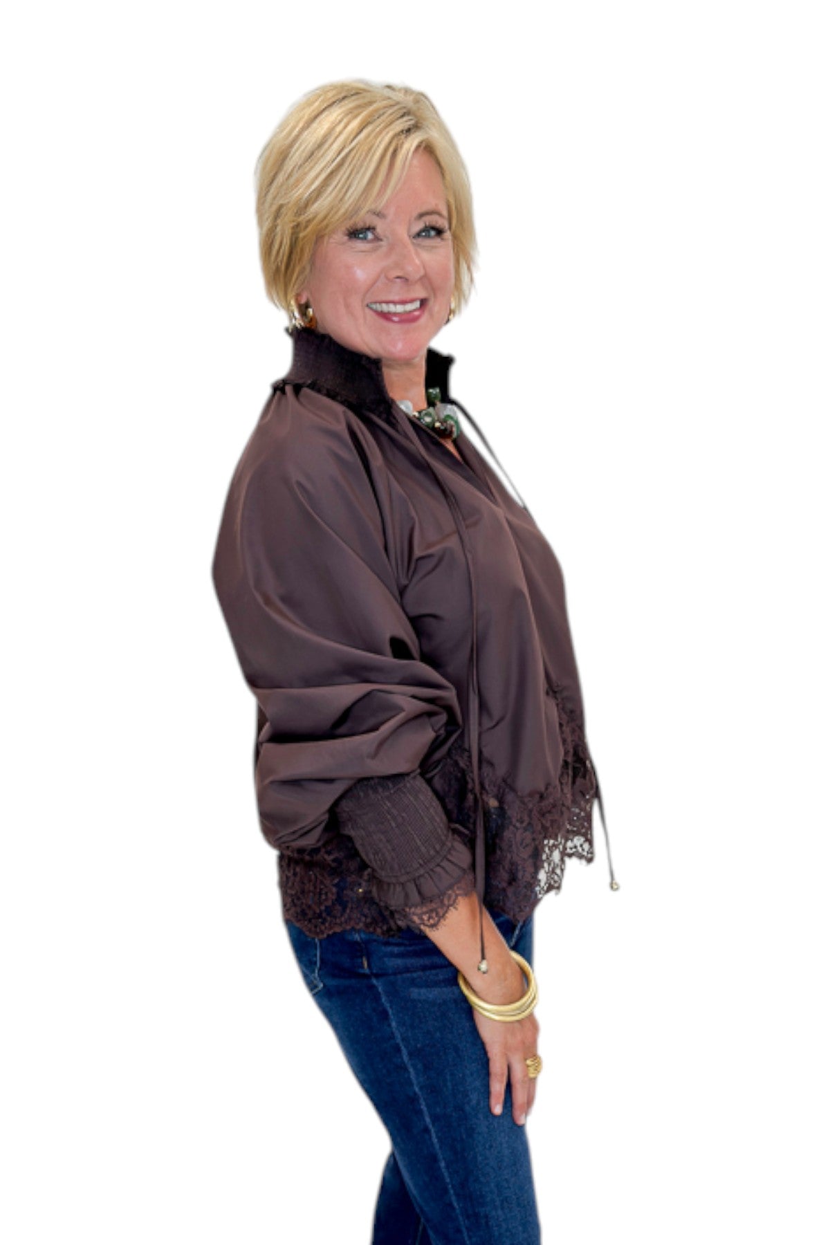 Side view of woman wearing Swagger Boutique’s Chocolate Lace Lined Top by Entro with jeans against white studio background.