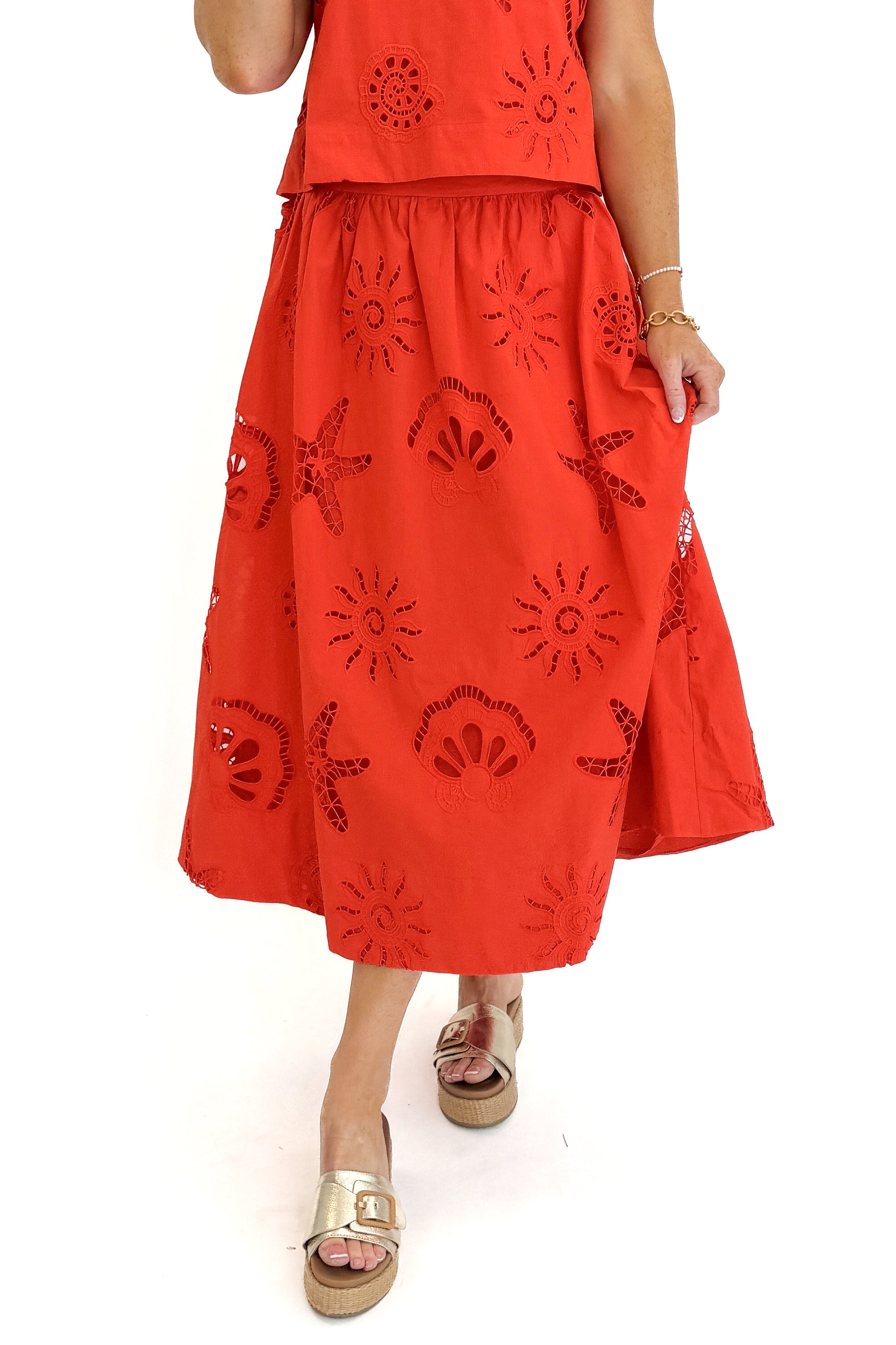 Front detail view of woman wearing Swagger Boutiqueβs Coral Shell Embroidered Tank with matching Coral Shell Embroidered Midi Skirt against white studio background.