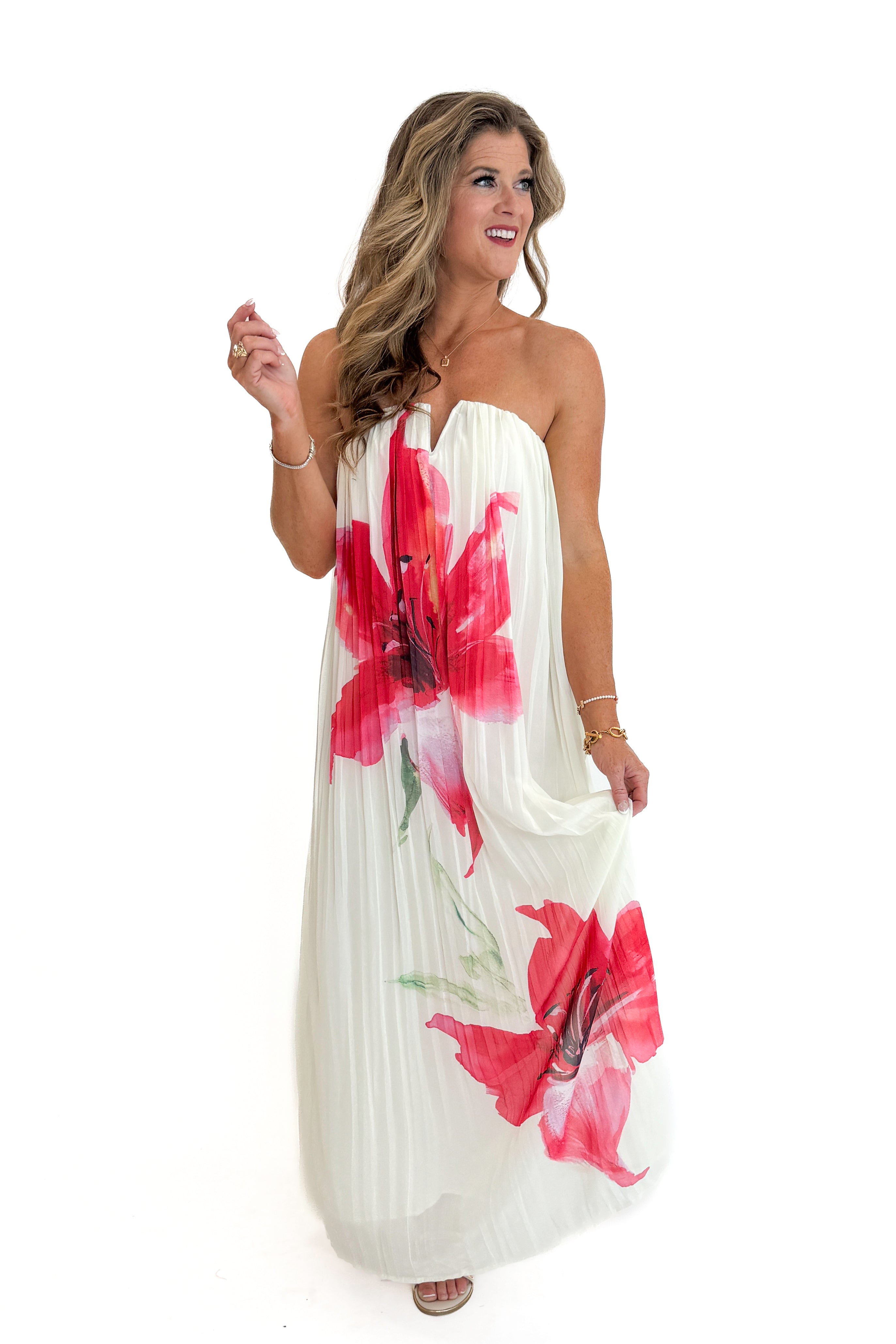 Front view of woman wearing Swagger Boutiqueβs Cream With Large Floral Print Pleat Detail Maxi Dress with sandals against white studio background.