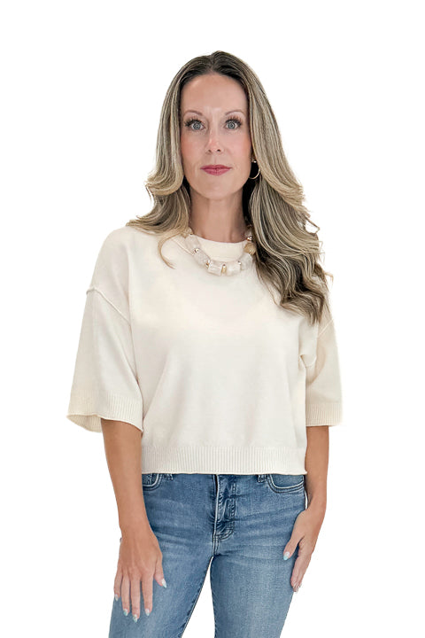 Front view of woman wearing Swagger Boutiqueās Cream 3/4 Sleeve Lightweight Sweater by Entro with jeans against white studio background.