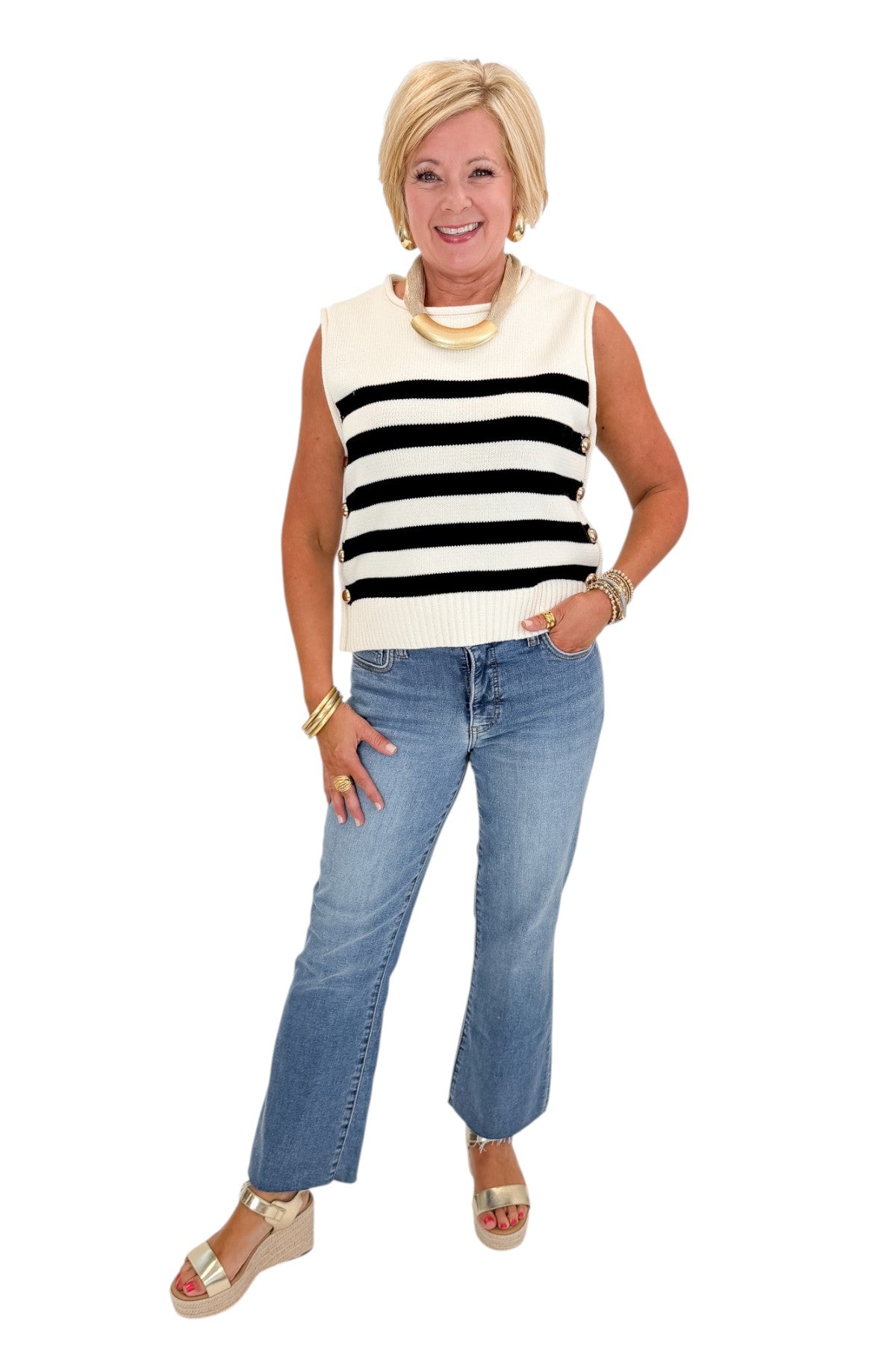 front view of woman wearing cap sleeve white and black striped knit sweater.