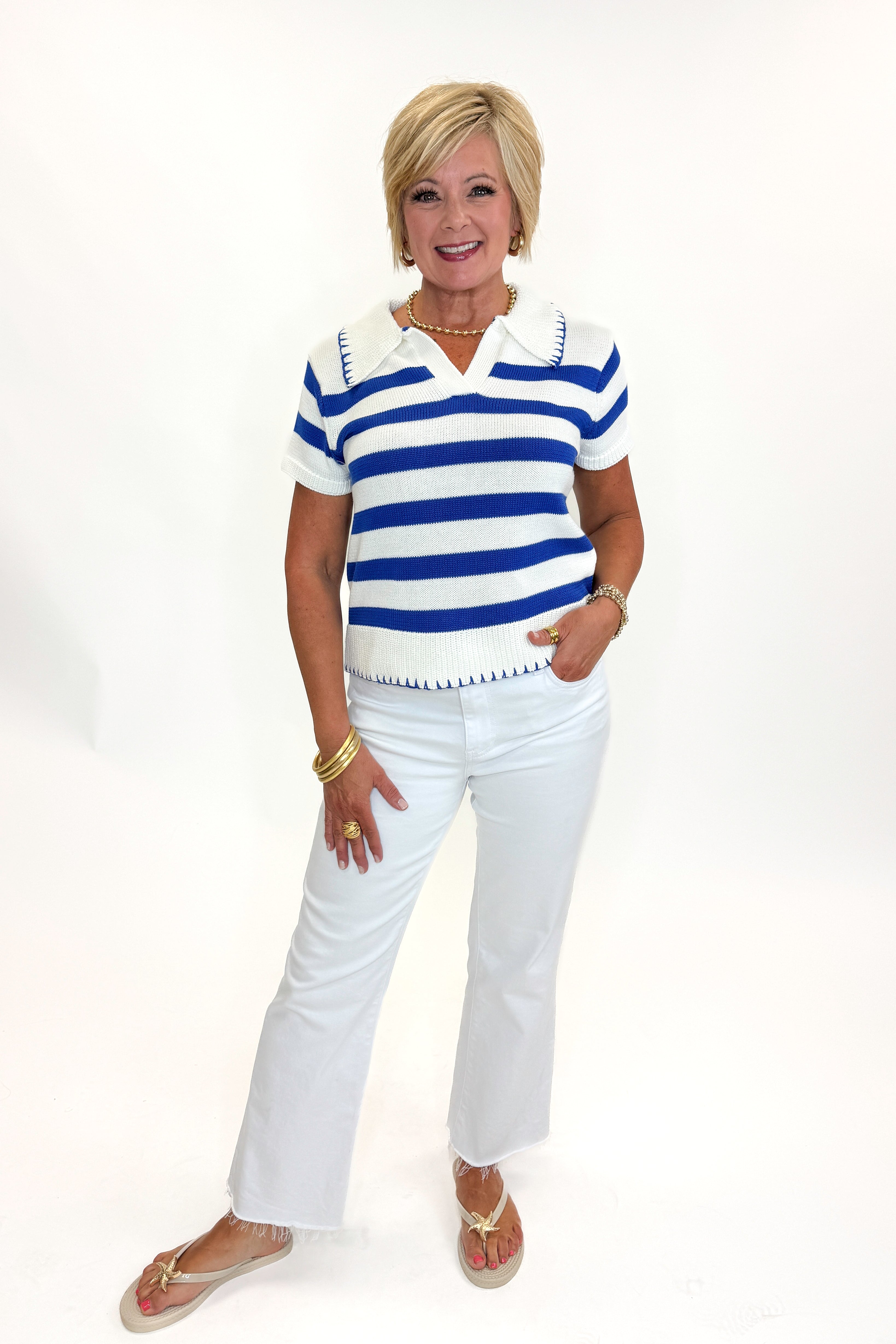 Front view of woman wearing Swagger Boutique’s Cream & Blue Striped Knit Top by Skies Are Blue with jeans against white studio background.