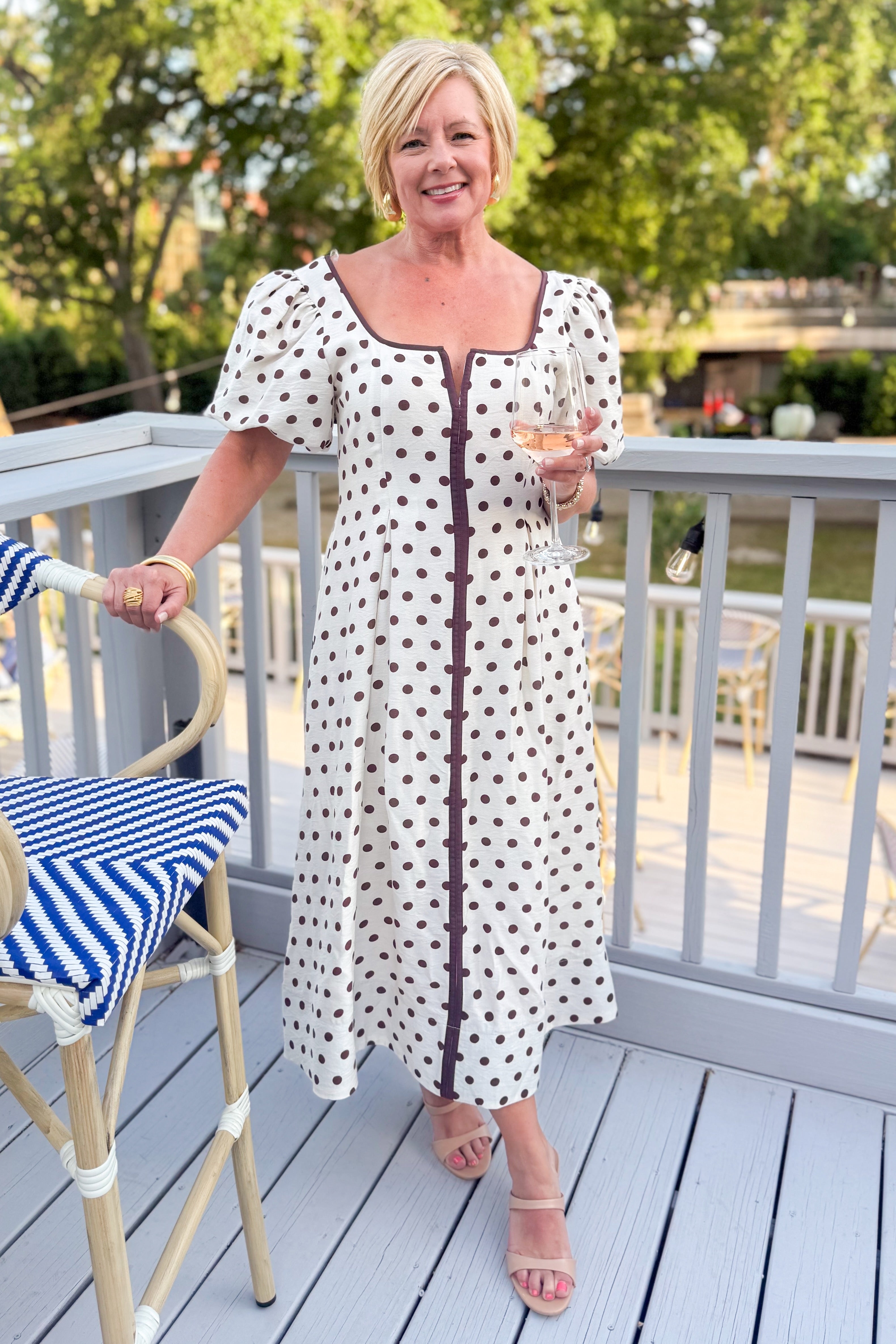 Front view of woman wearing Cream With Brown Stripe Detail Polka Dot Midi Dress by Entro outside at a restaurant.