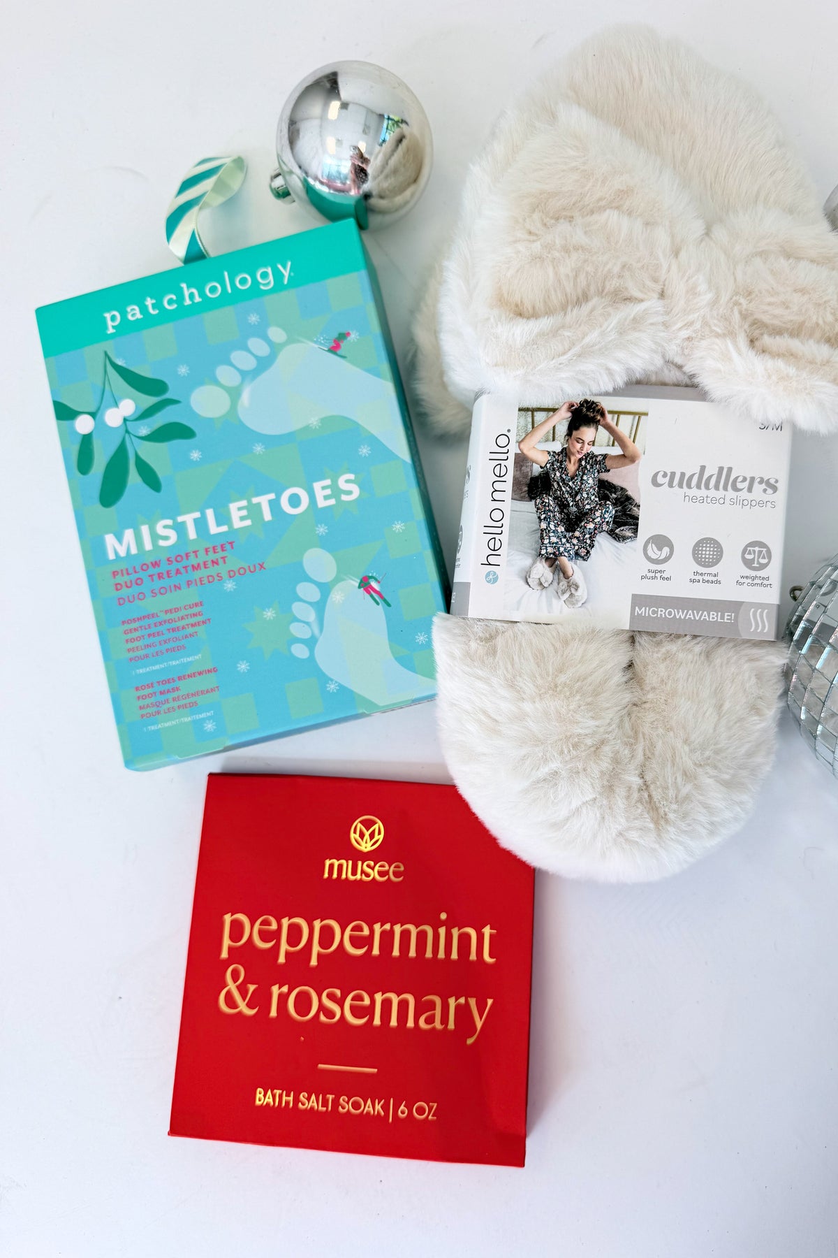 Cuddlers Heated Slippers & Spa items against studio background.