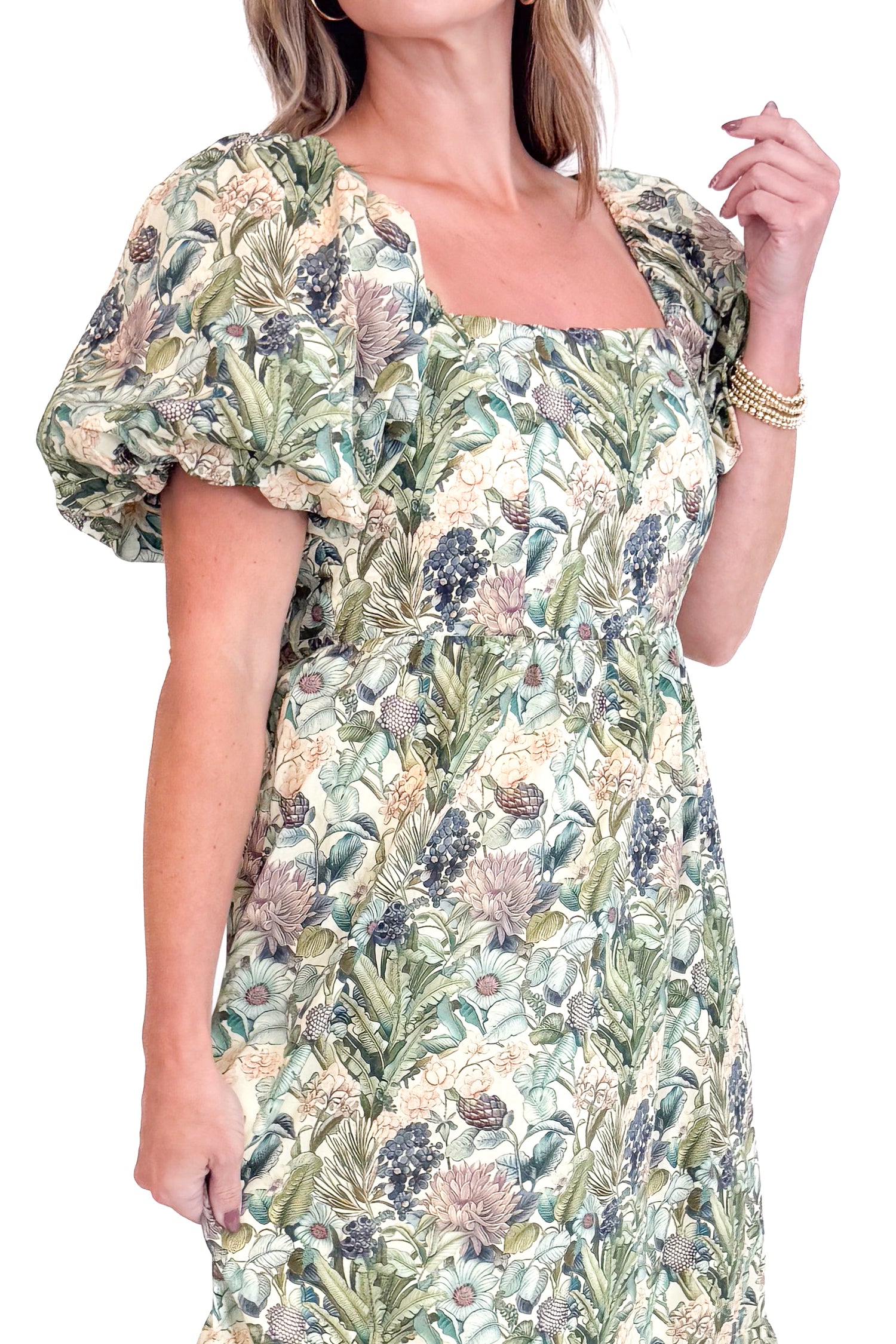 Woman wearing a floral dress with puff sleeves on a white background