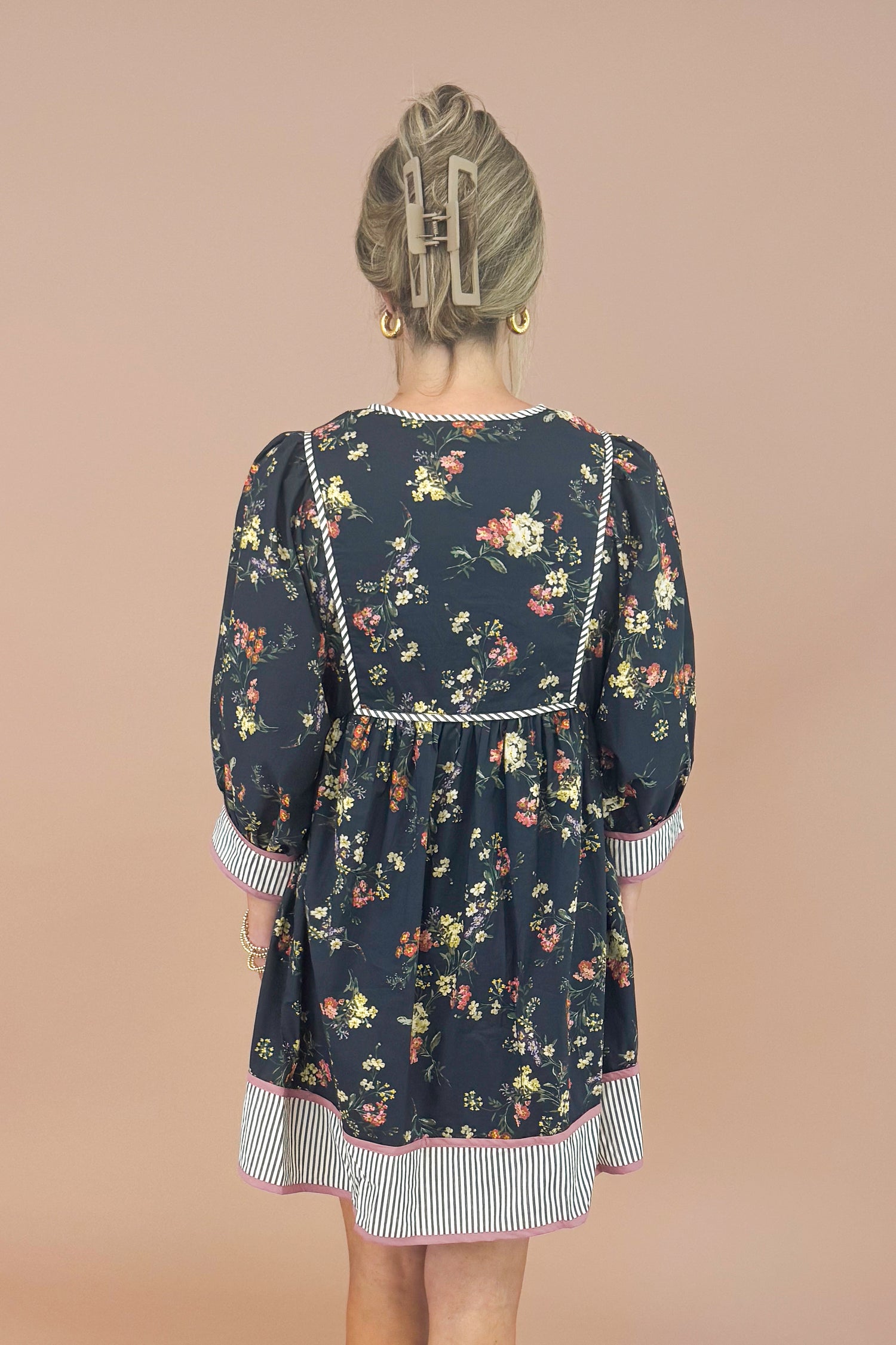 Woman wearing a floral dress with a plain background