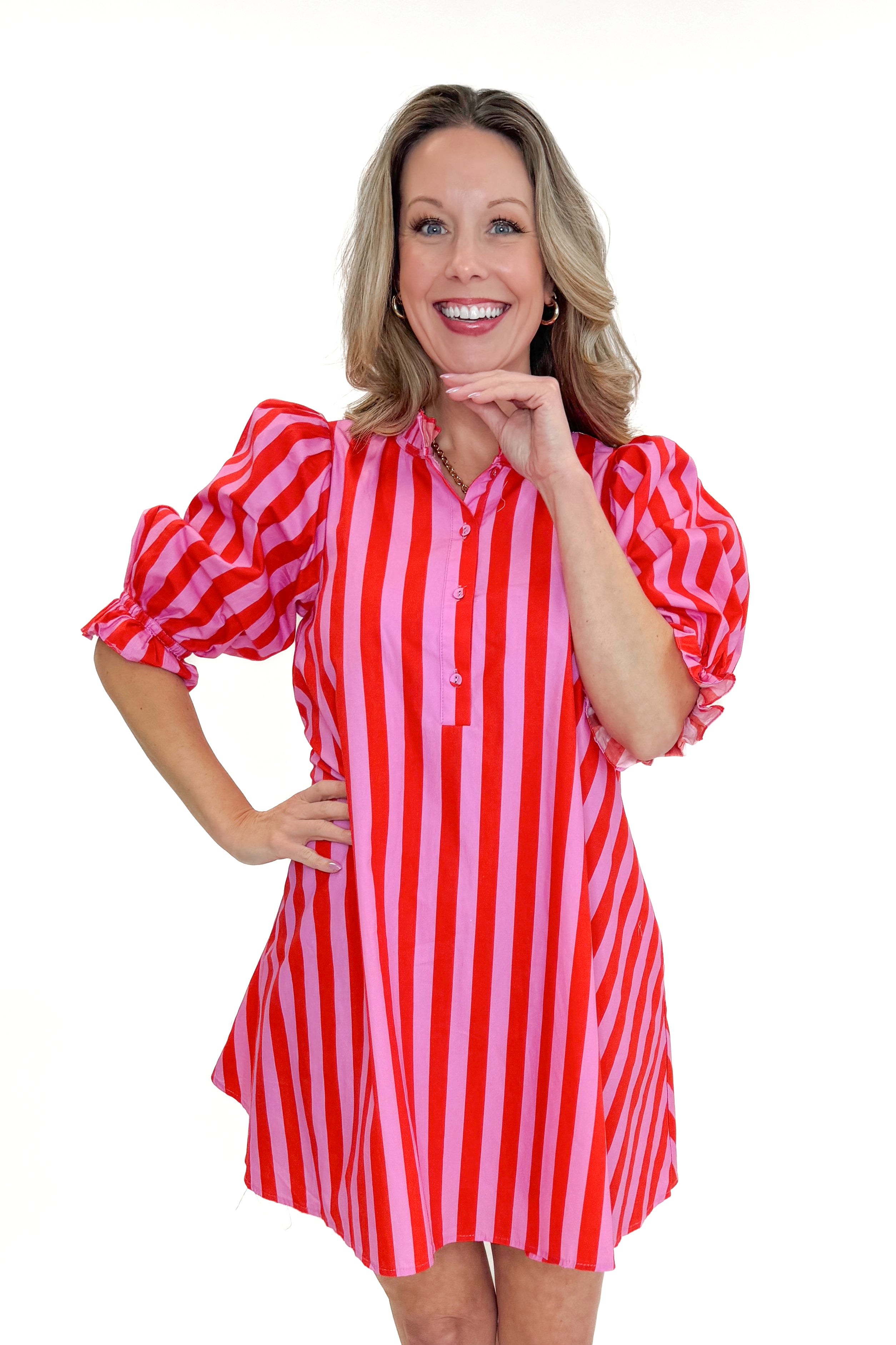 Woman wearing a red and pink striped dress on a white background
