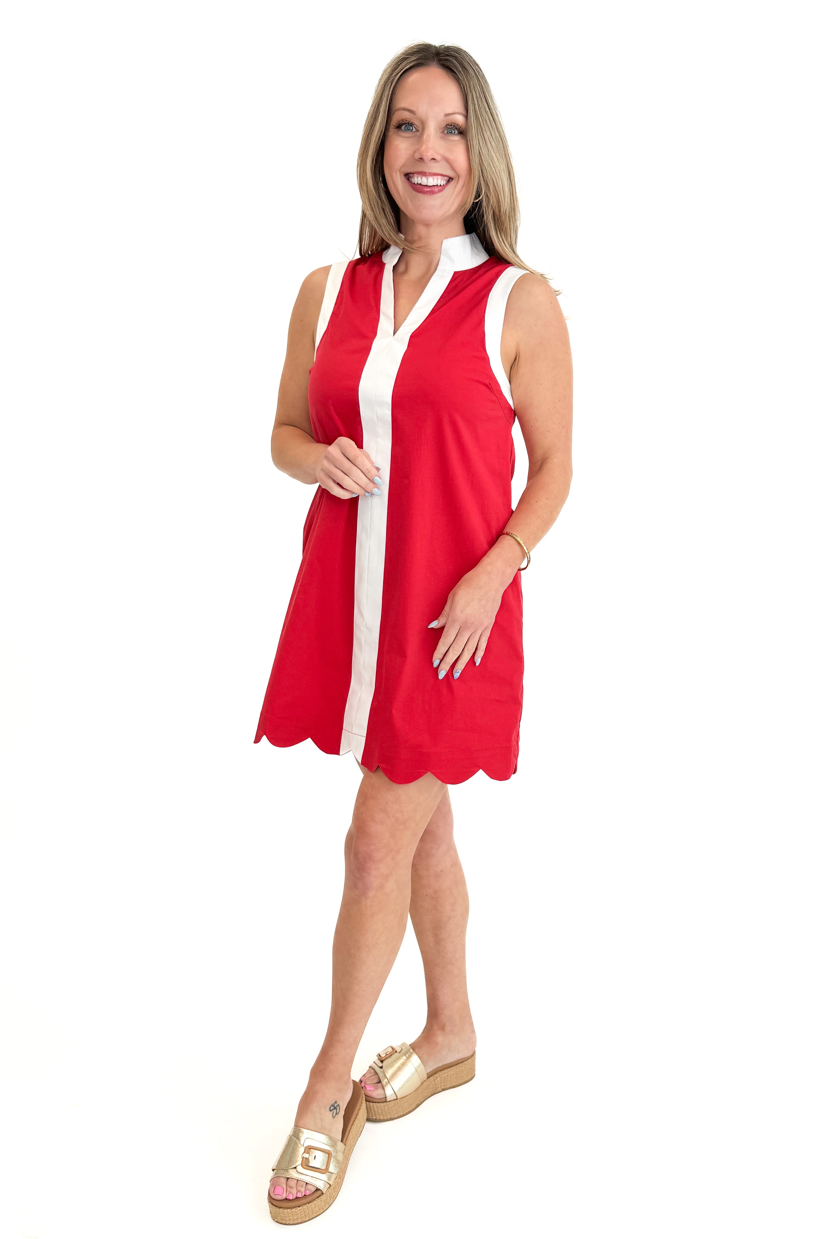 Side view of woman wearing Red With Center Stripe Scallop Hem Dress by Entro against white studio background.