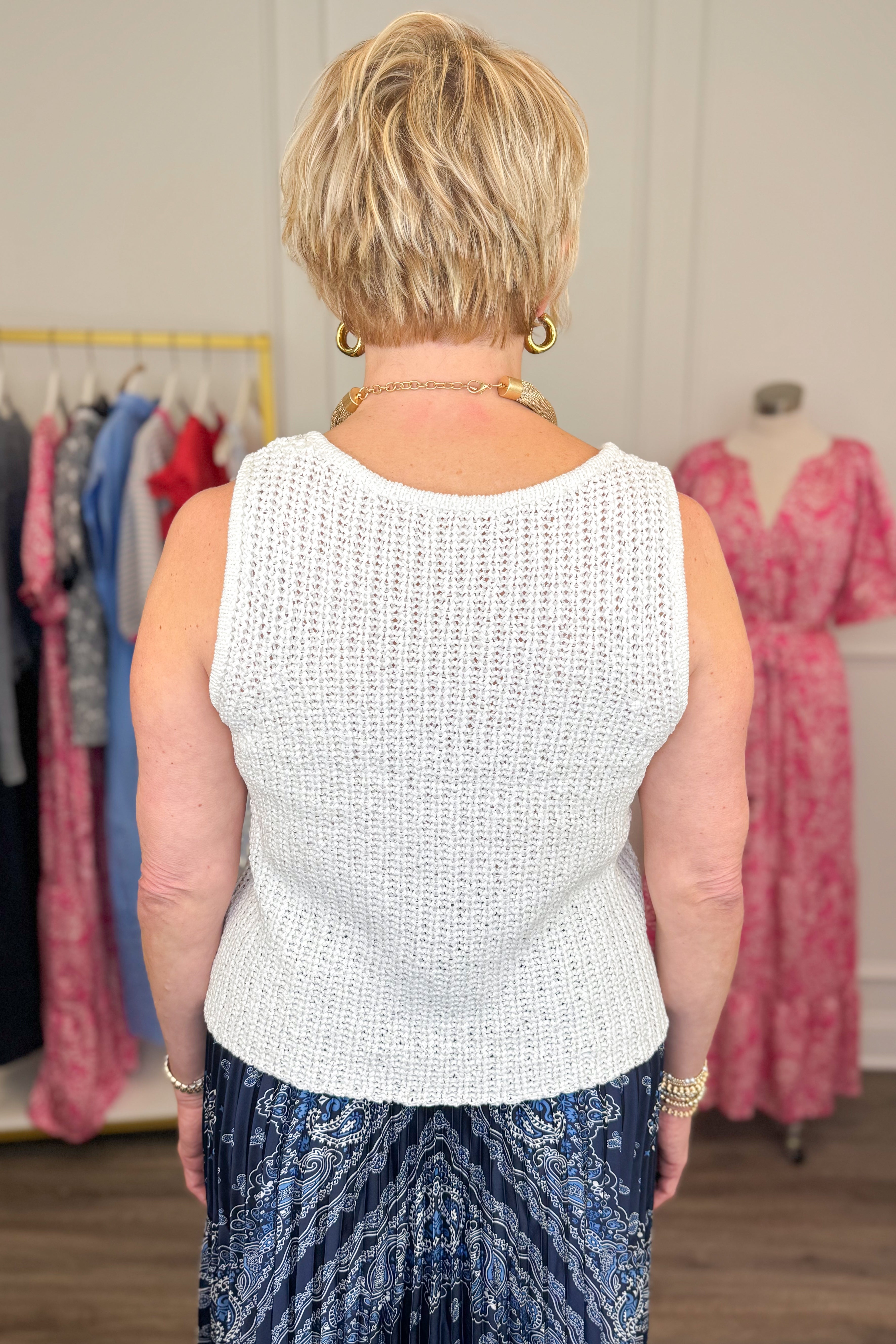 Back view of woman wearing White V-Neck Knitted Tank by Skies Are Blue with skirt.