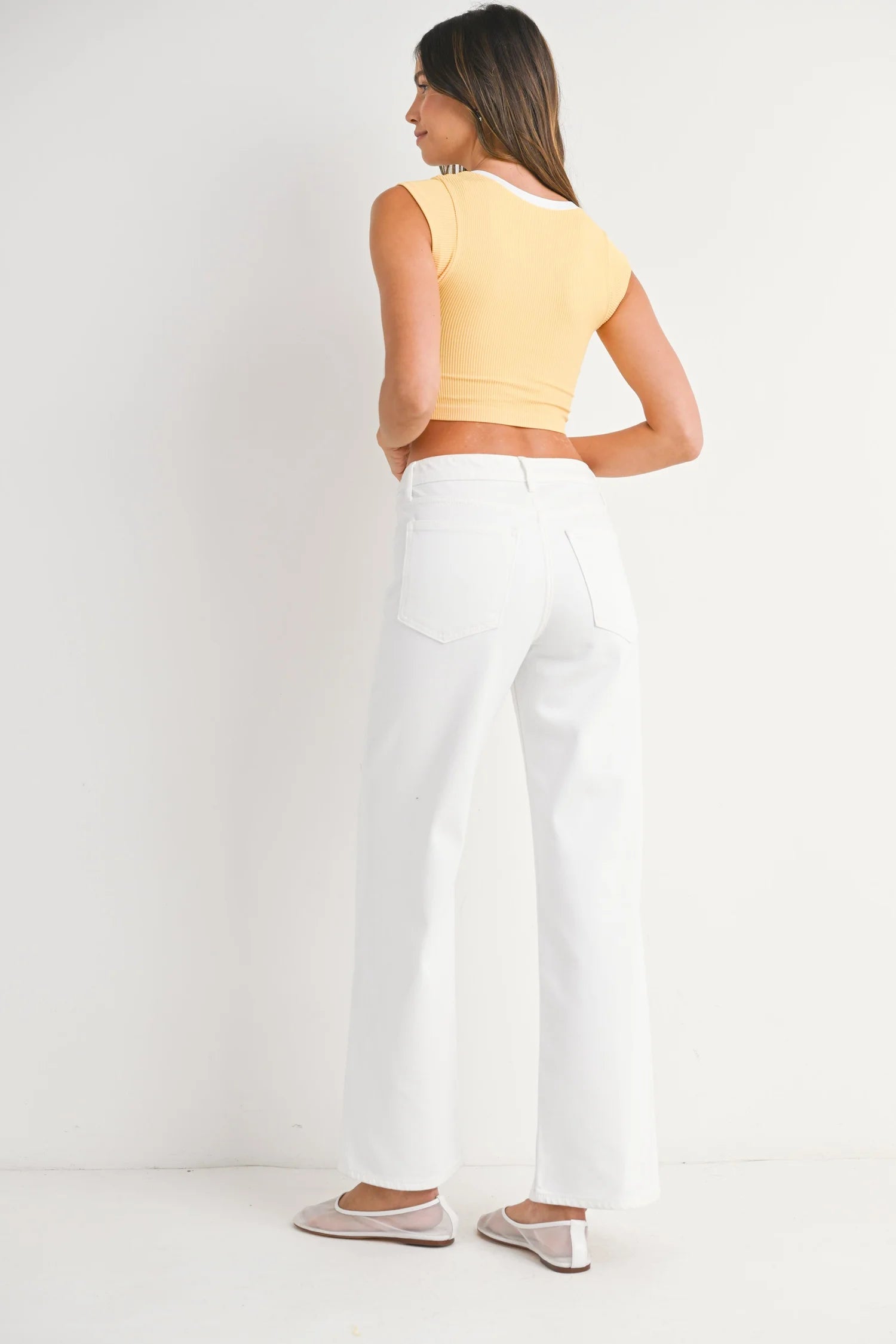 Stock photo with back view of model wearing White Straight Leg Jeans by Just Black Denim against white studio background.