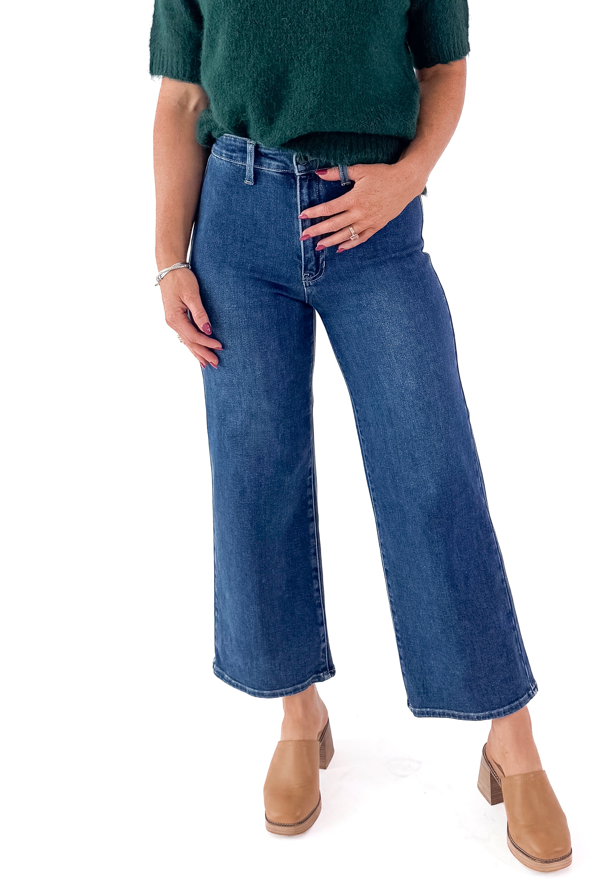 Front view of woman wearing green sweater with Dark Wash No Pocket Trouser Jeans against white studio background.