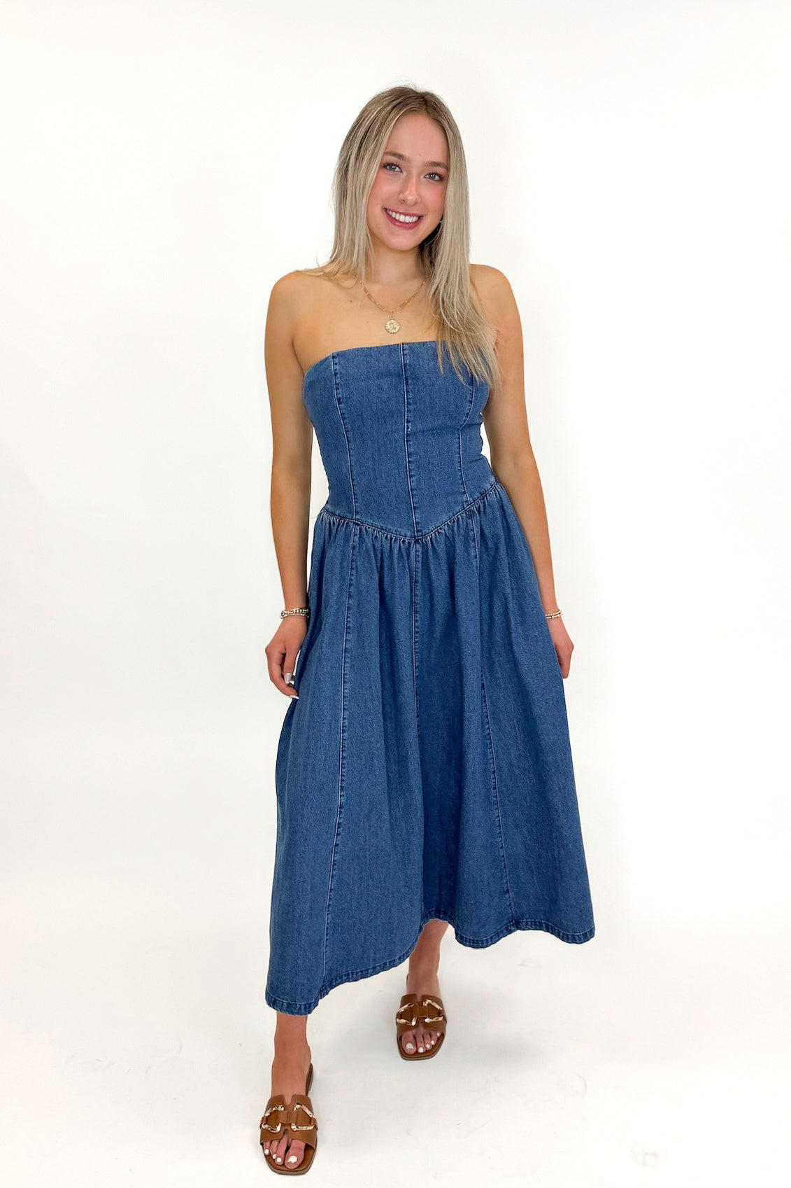 Front view of woman wearing Denim V-Waist Midi Dress with sandals against white studio background.