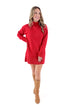 Front view of woman wearing red sweater dress with boots against white studio background.