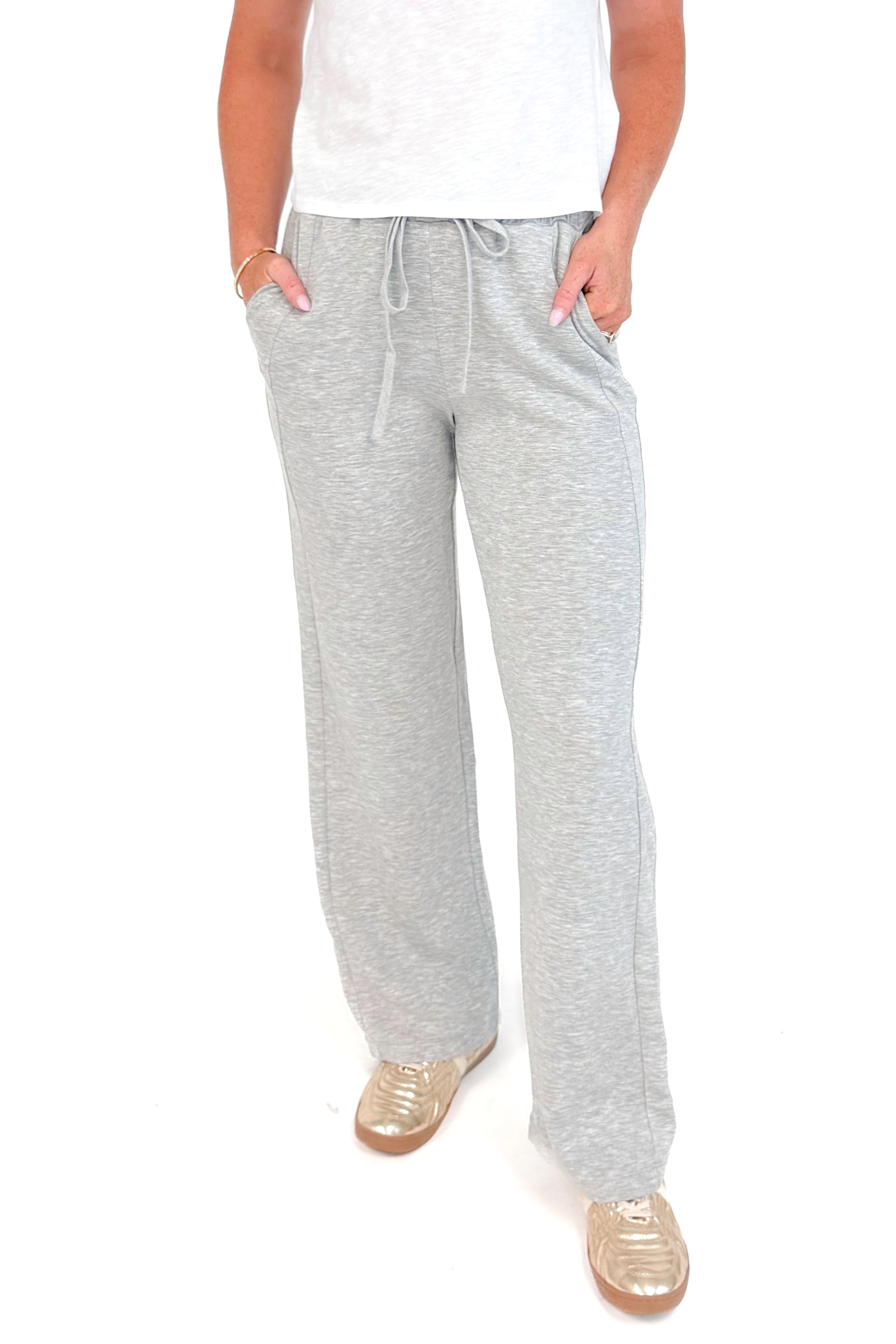 Front detail view of grey sweatpants and white top.