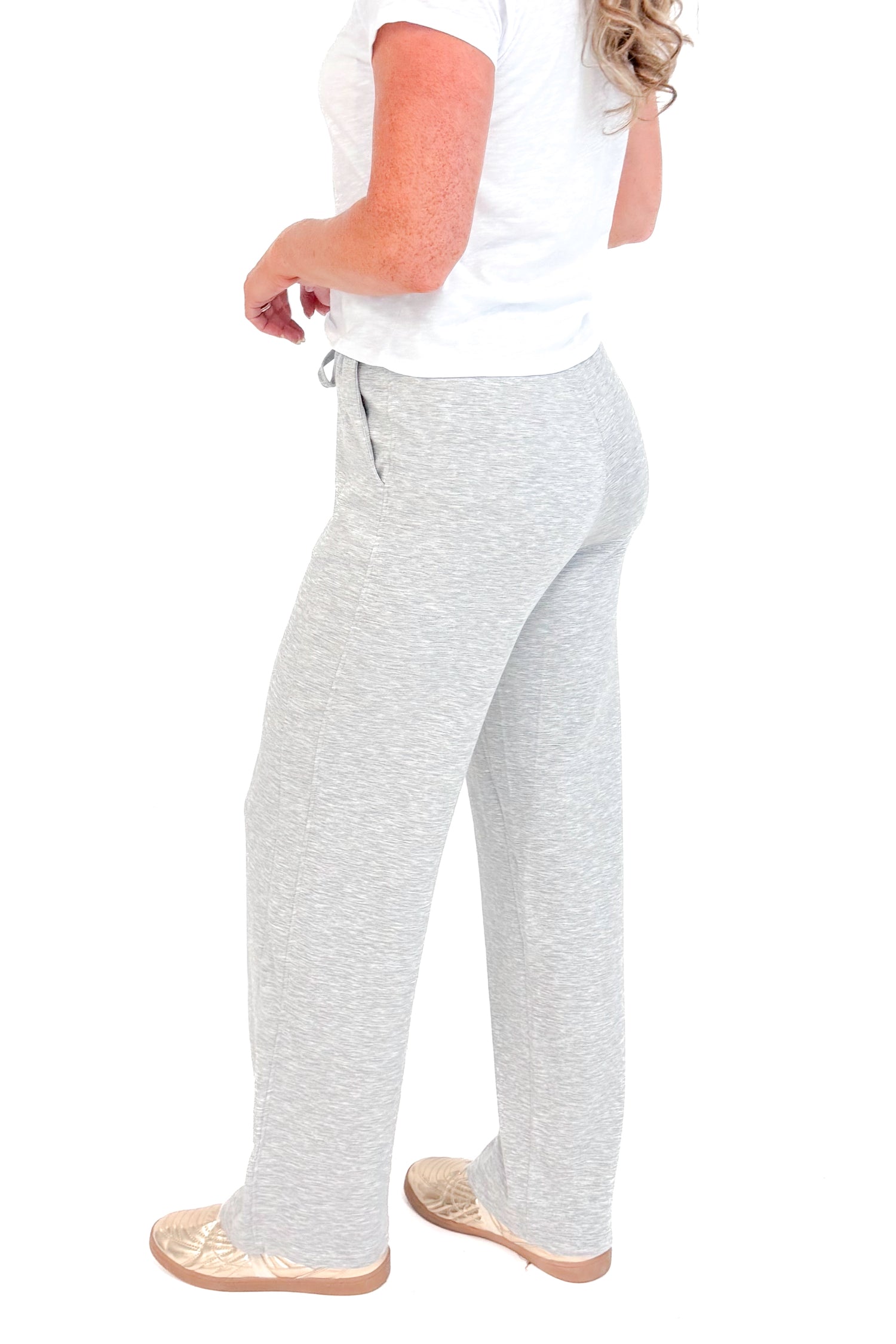 Side view of grey sweatpants and white top.