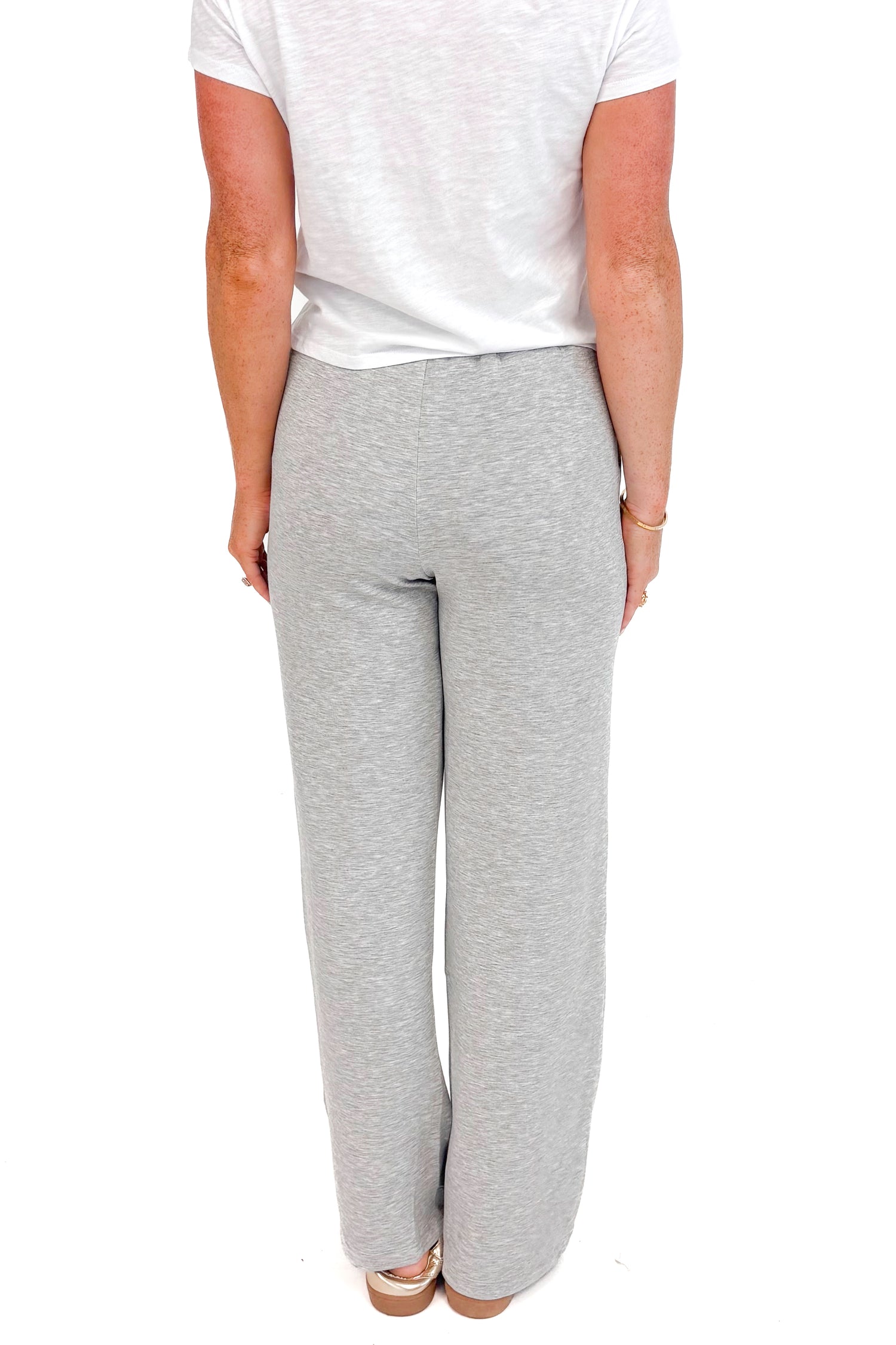 Back view of grey sweatpants and white top.
