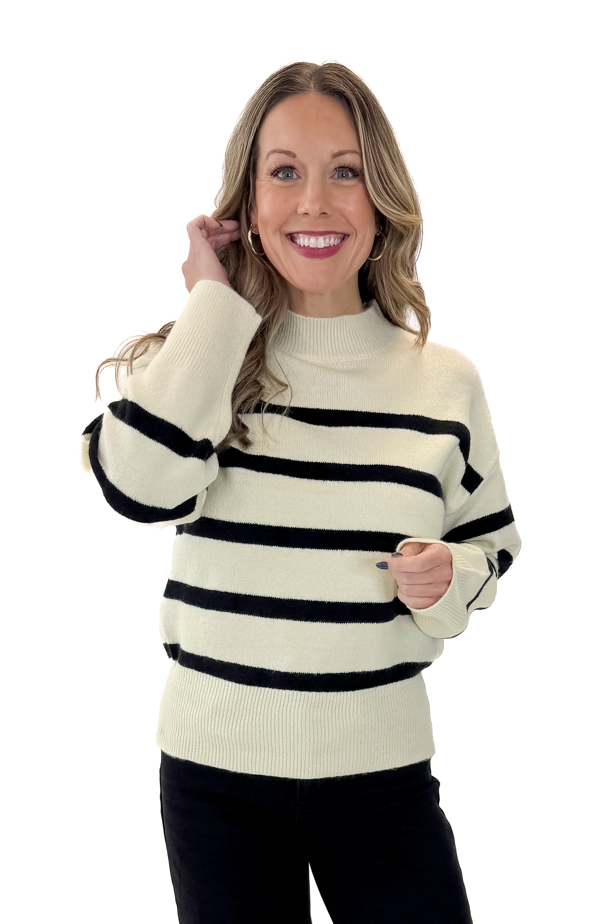 Front view of woman wearing Black & Cream Striped Mock Neck Sweater with jeans against white studio background.