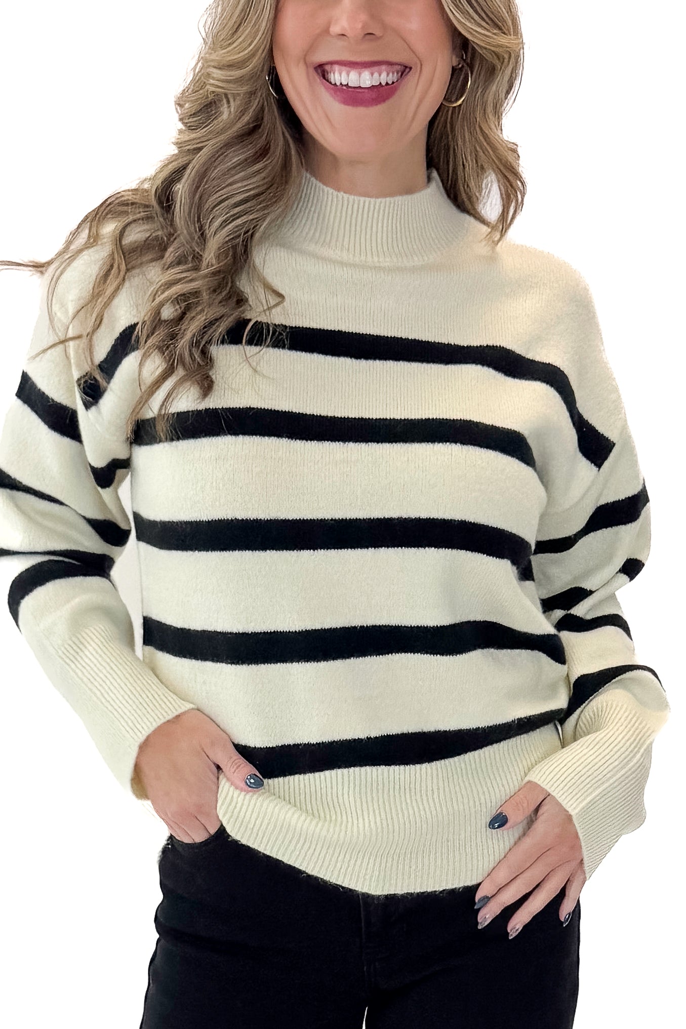 Front view of woman wearing Black & Cream Striped Mock Neck Sweater with jeans against white studio background.