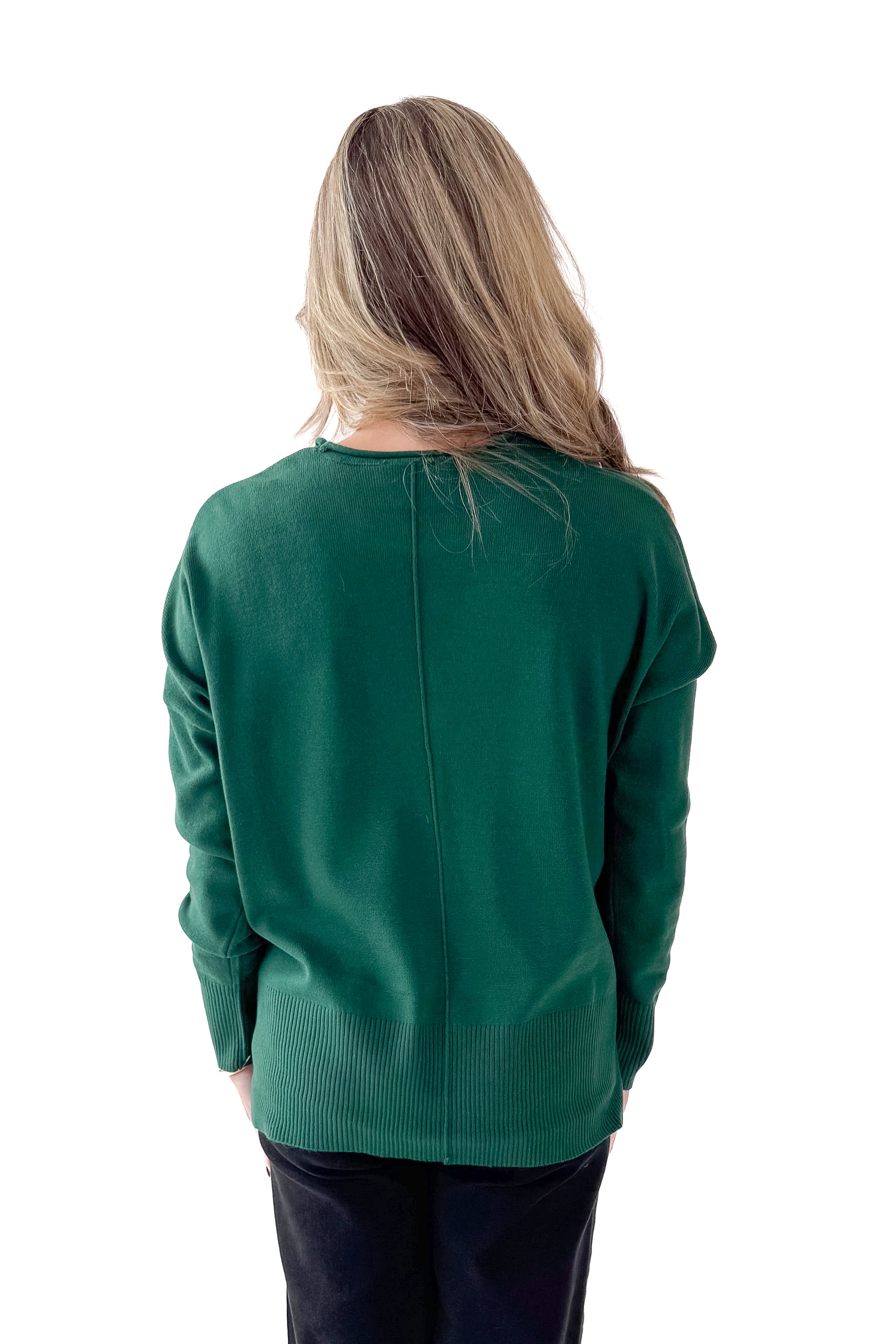 Back view of woman wearing Green Center Seam Round Neck Sweater with jeans against white studio background.