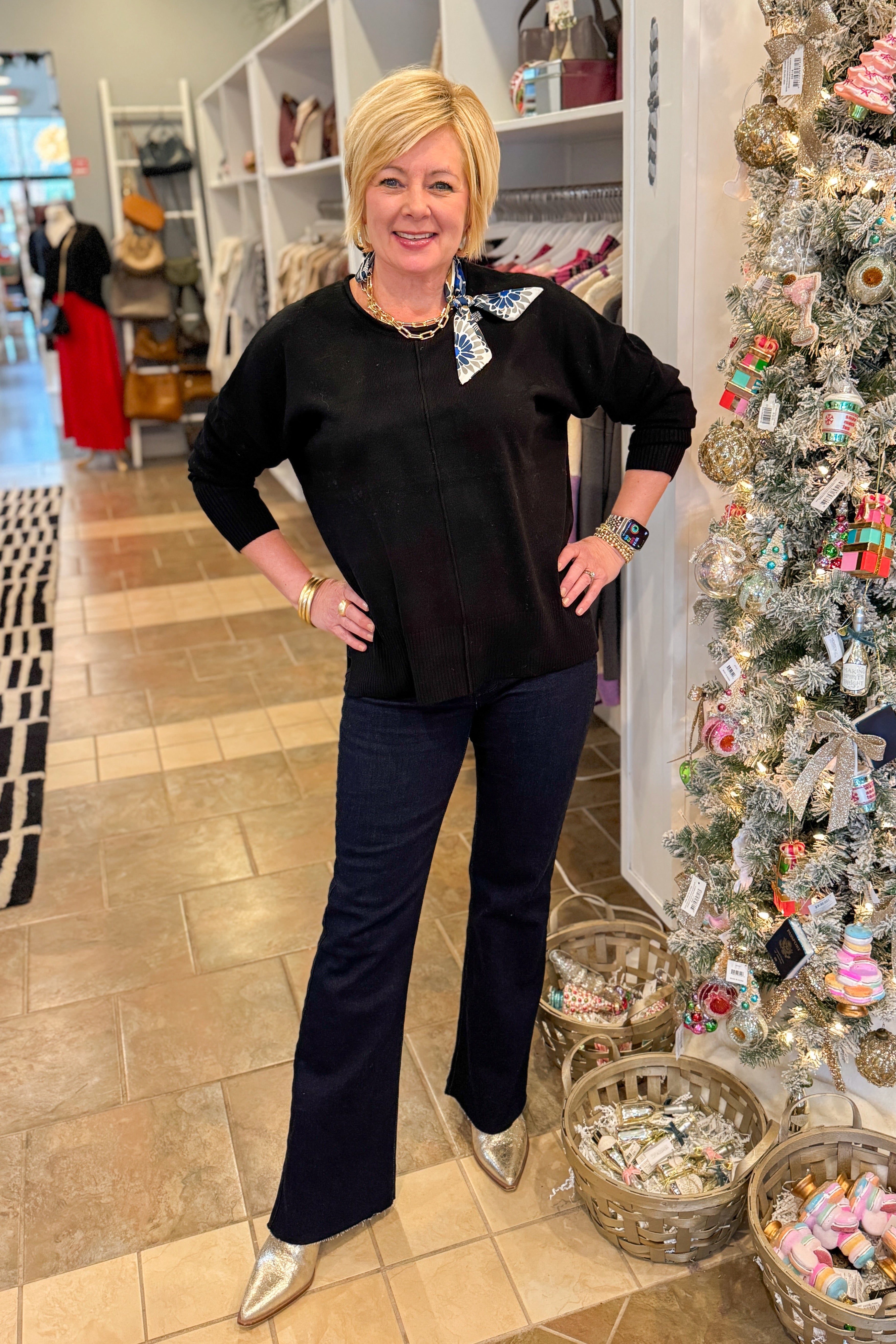 Front view of woman wearing Black Center Seam Round Neck Sweater with jeans at a boutique.