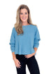 Woman wearing a blue sweater and black pants on a white background