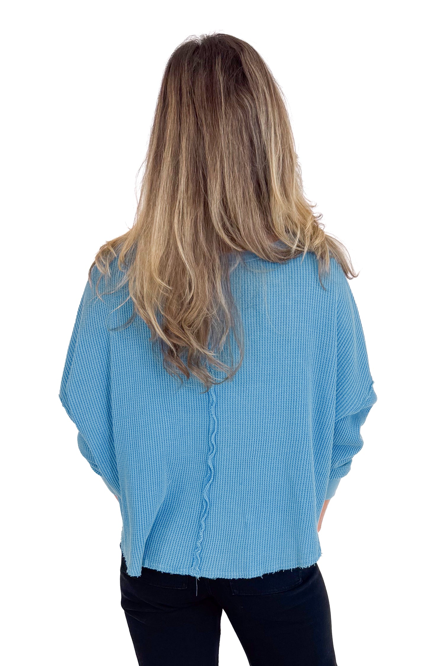 Person wearing a blue textured sweater on a white background
