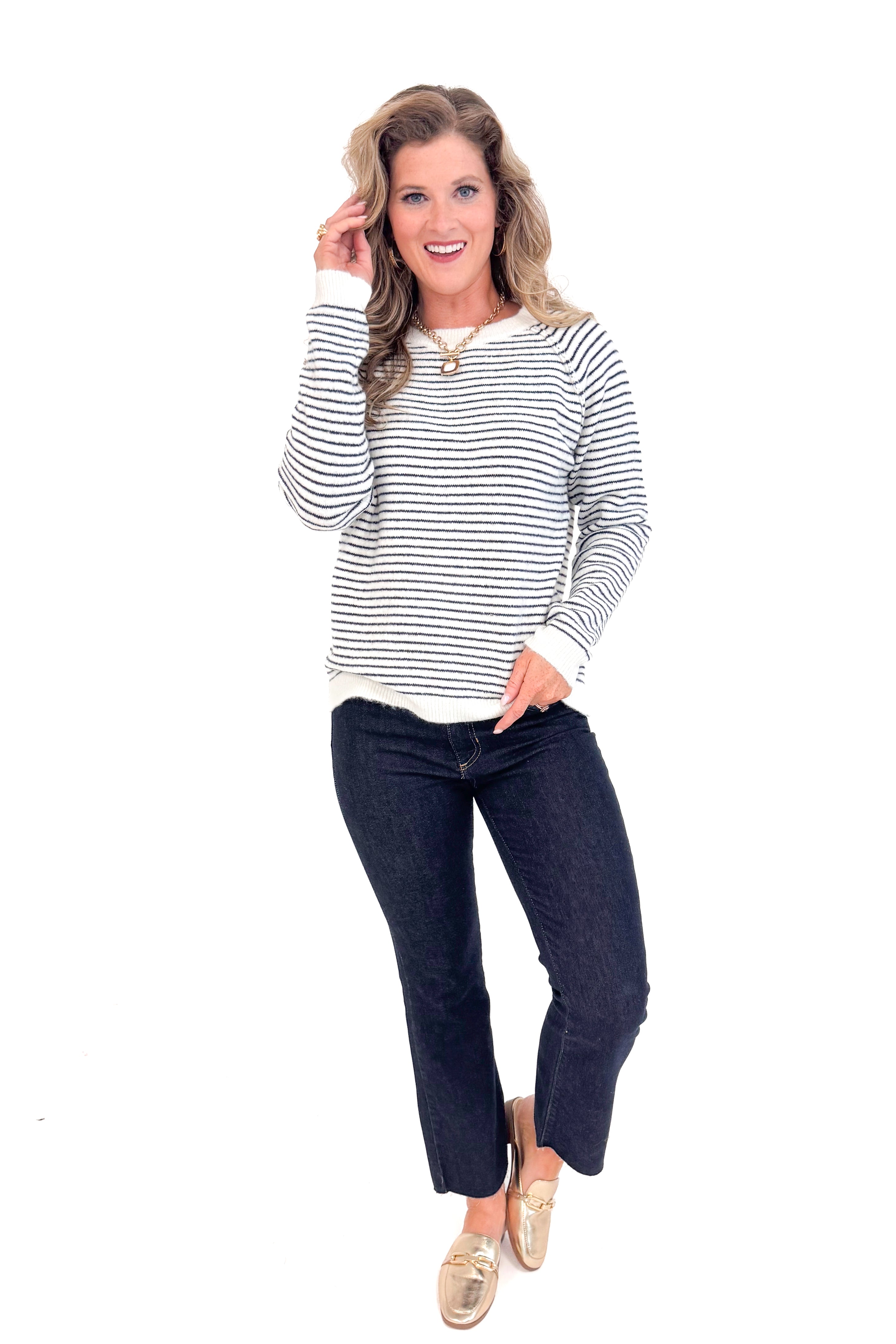 Woman wearing Cream & Black Striped Long Sleeve Top and blue jeans full front length.