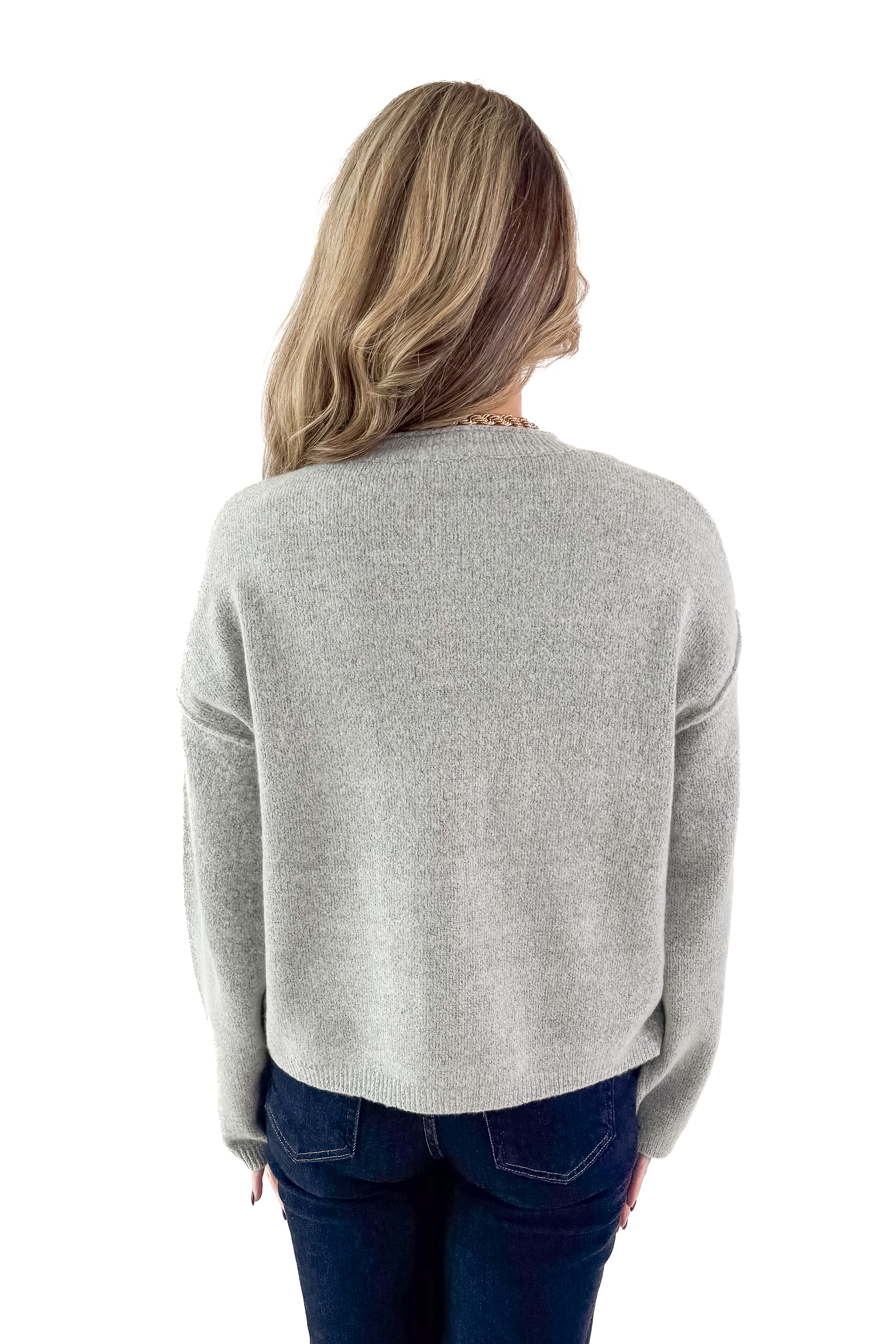 Back view of woman wearing Heather Grey Button Up Cardigan with jeans against white studio background.