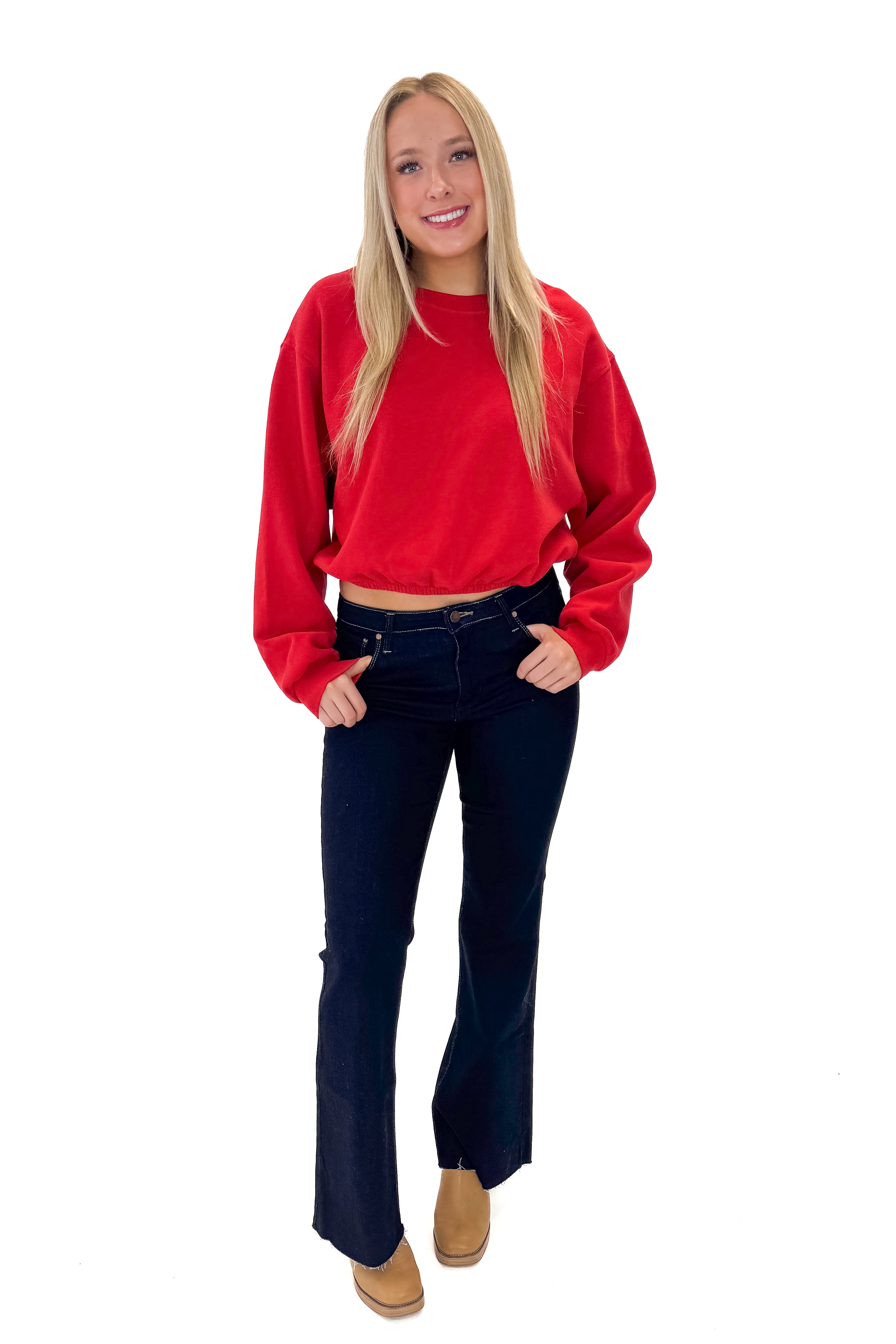 Front view of woman wearing Red Elastic Hem Sweatshirt with jeans against white studio background.