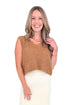 Front view of woman wearing caramel color sweater with cream skirt against white studio background.