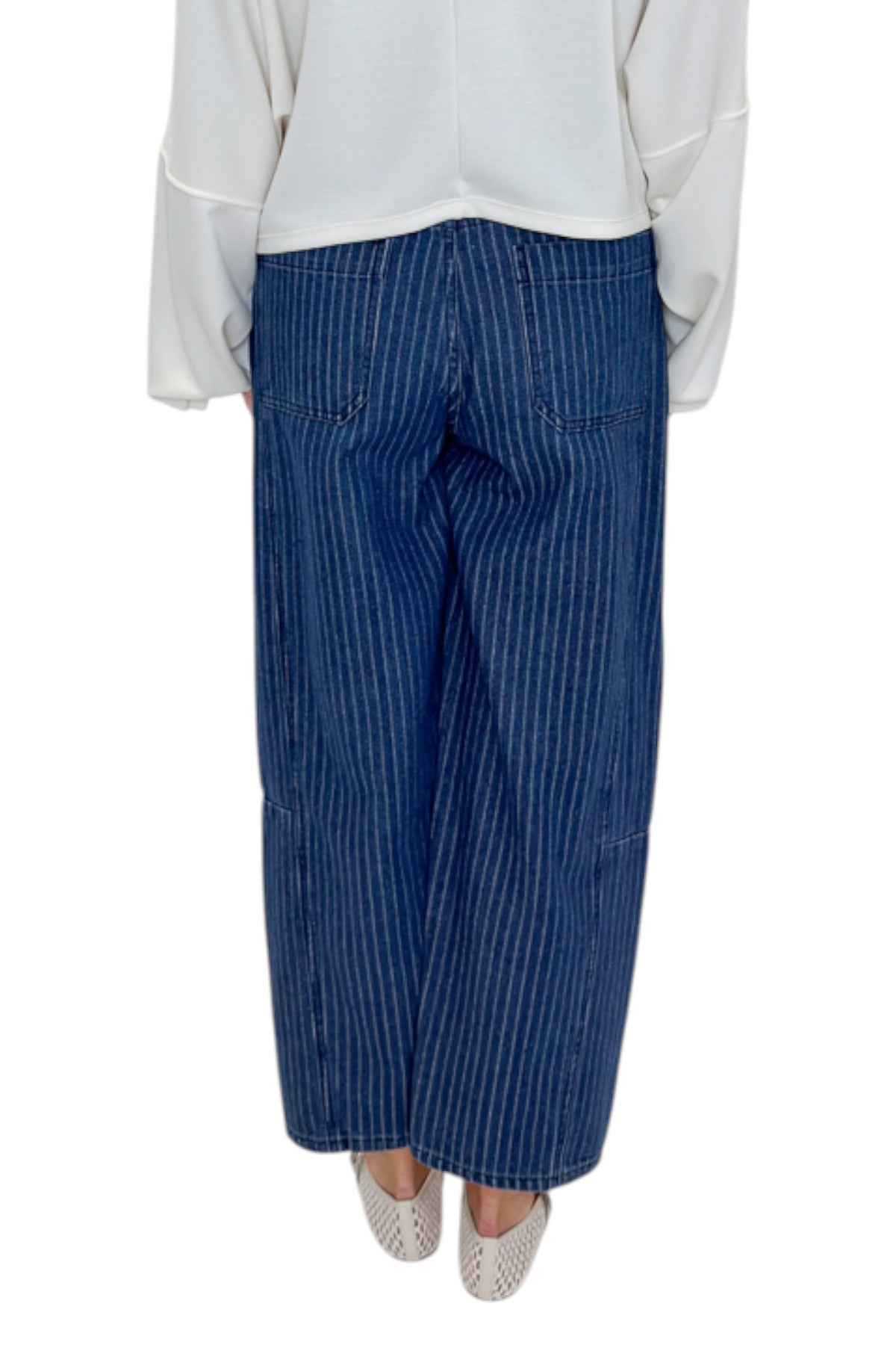 Back view of woman wearing Swagger Boutique’s Dark Wash Pinstriped Barrel Jeans with top against white studio background.