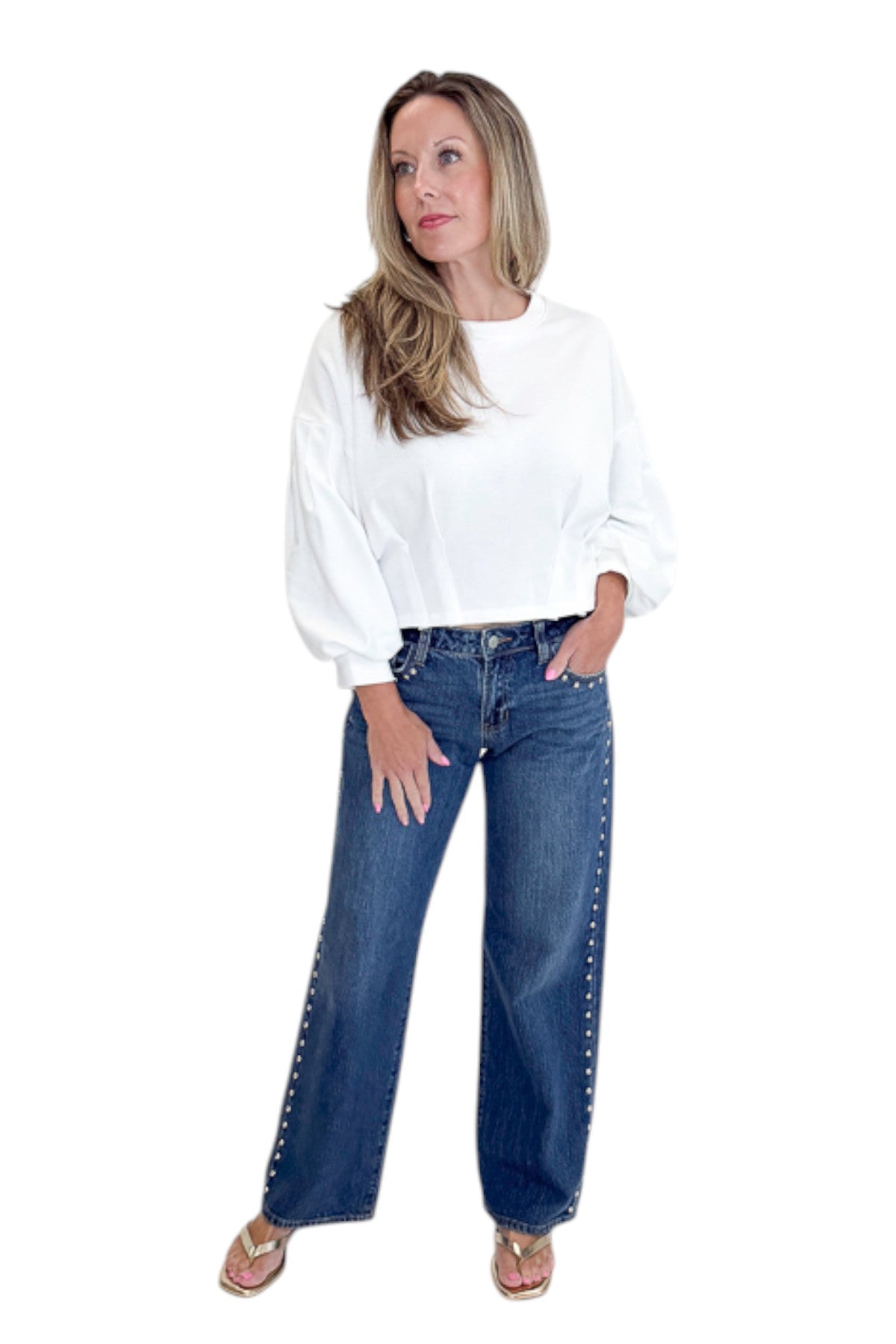 Front view of woman wearing Swagger Boutiqueās sweater with Dark Wash Stud Jeans by Just Black Denim against white studio background.
