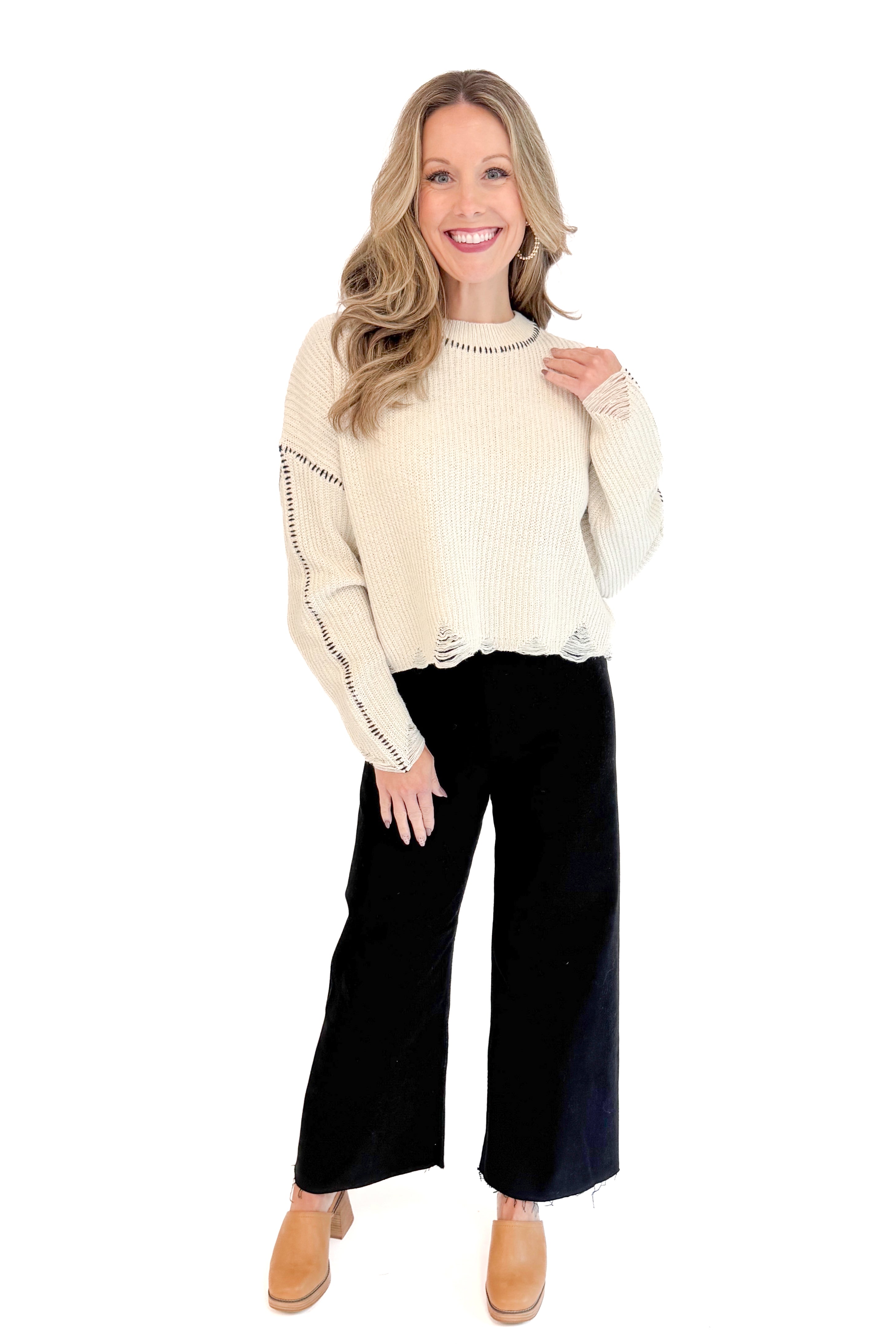 Front full length view of woman wearing stitch detail oatmeal sweater.
