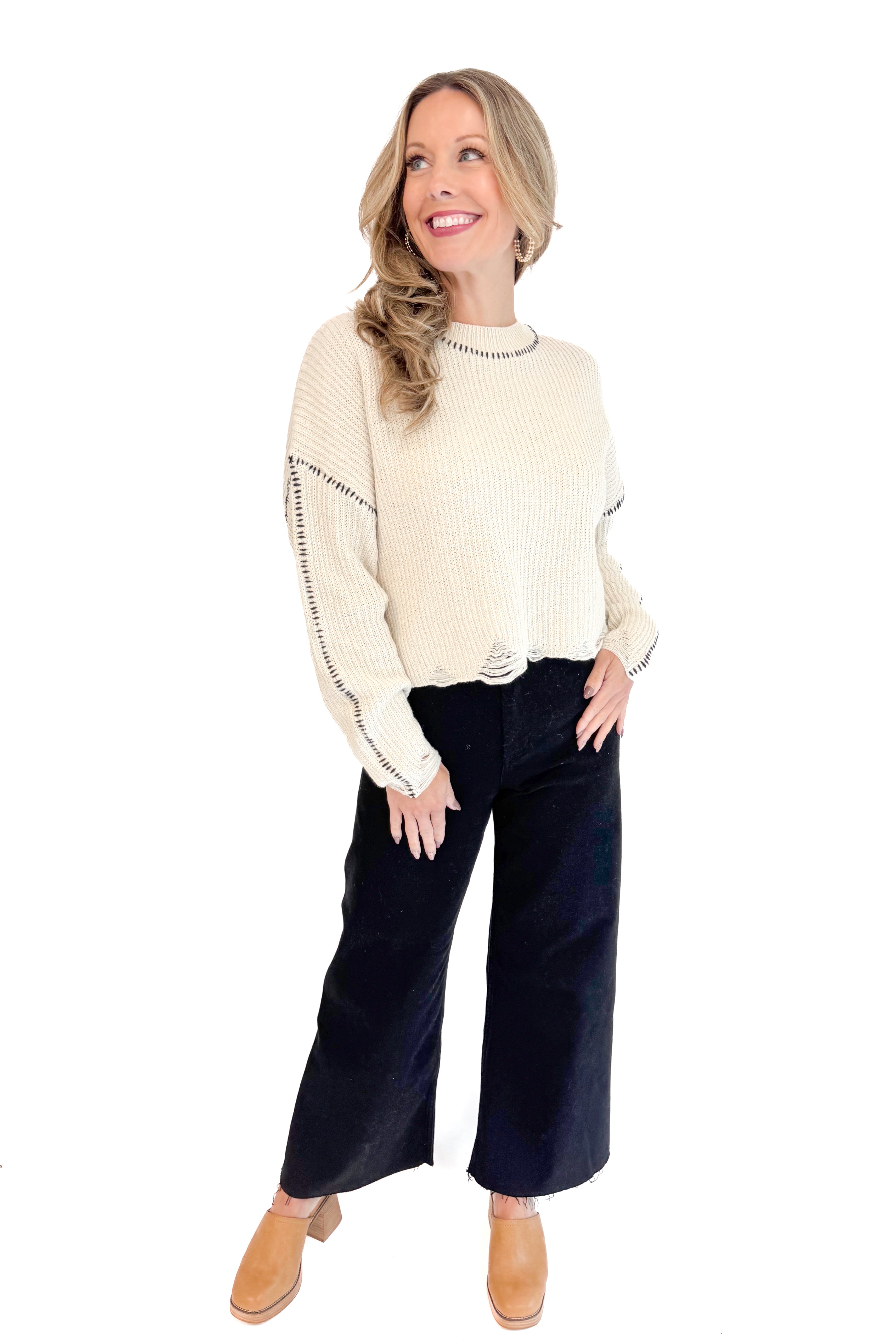 Front full length view of woman wearing stitch detail oatmeal sweater.