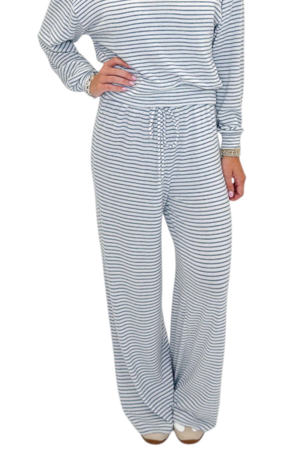 Front view of woman wearing Swagger Boutiqueās Eclipse Classic Stripe Pants by Z Supply with Long Sleeve Top against white studio background.