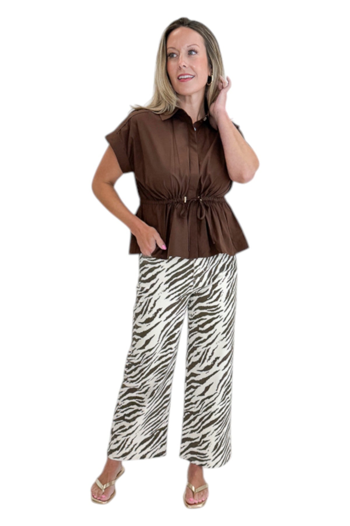 Front view of woman wearing Swagger Boutiqueβs Brown Cinched Waist Short Sleeve Top with zebra jeans against white studio background.