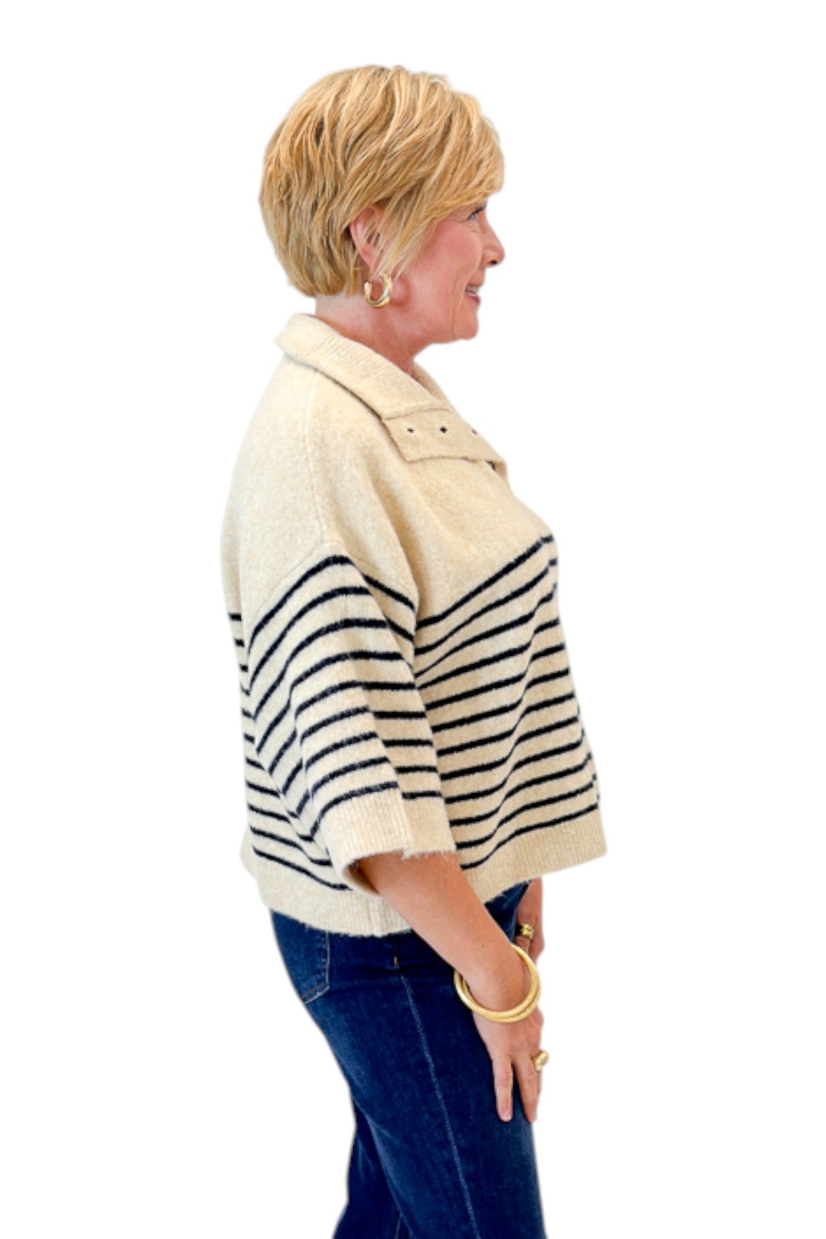 Side view of woman wearing Swagger Boutiqueās Ecru & Navy Striped 3/4 Sleeve Sweater by Entro with jeans against white studio background.